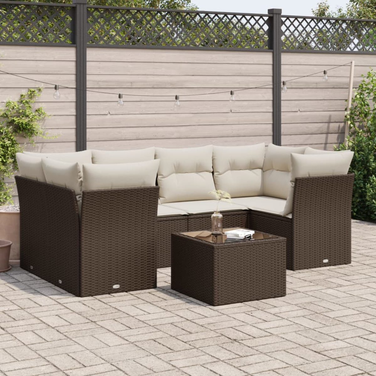 Area salotto esterna con mobili in rattan marrone e cuscini beige.