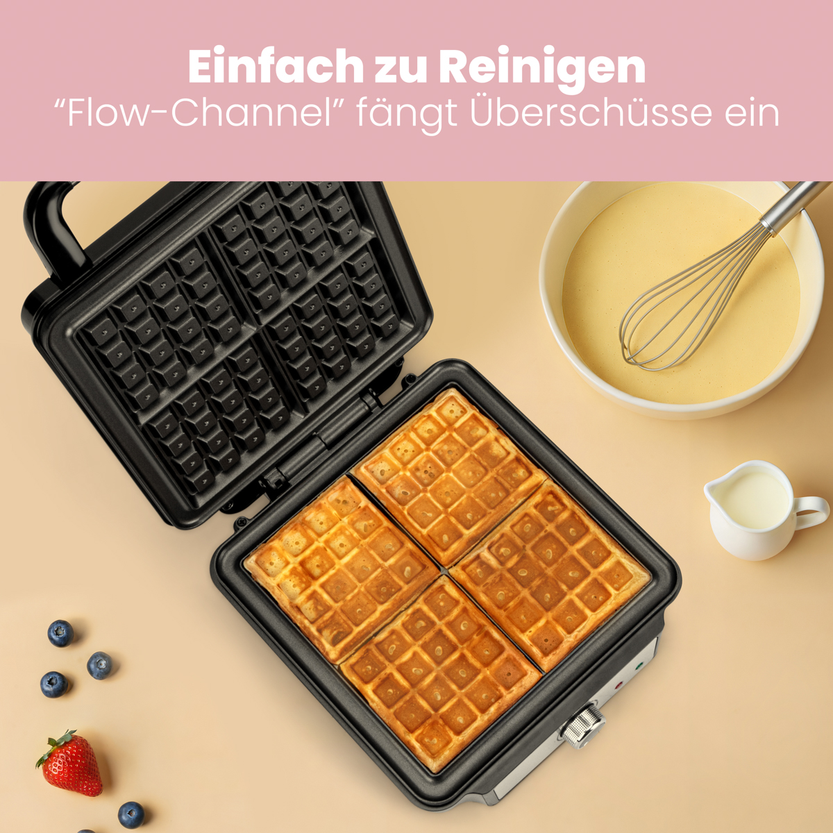 Gofry w gofrownicy. Miski z ciastem, śmietaną i jagodami obok.