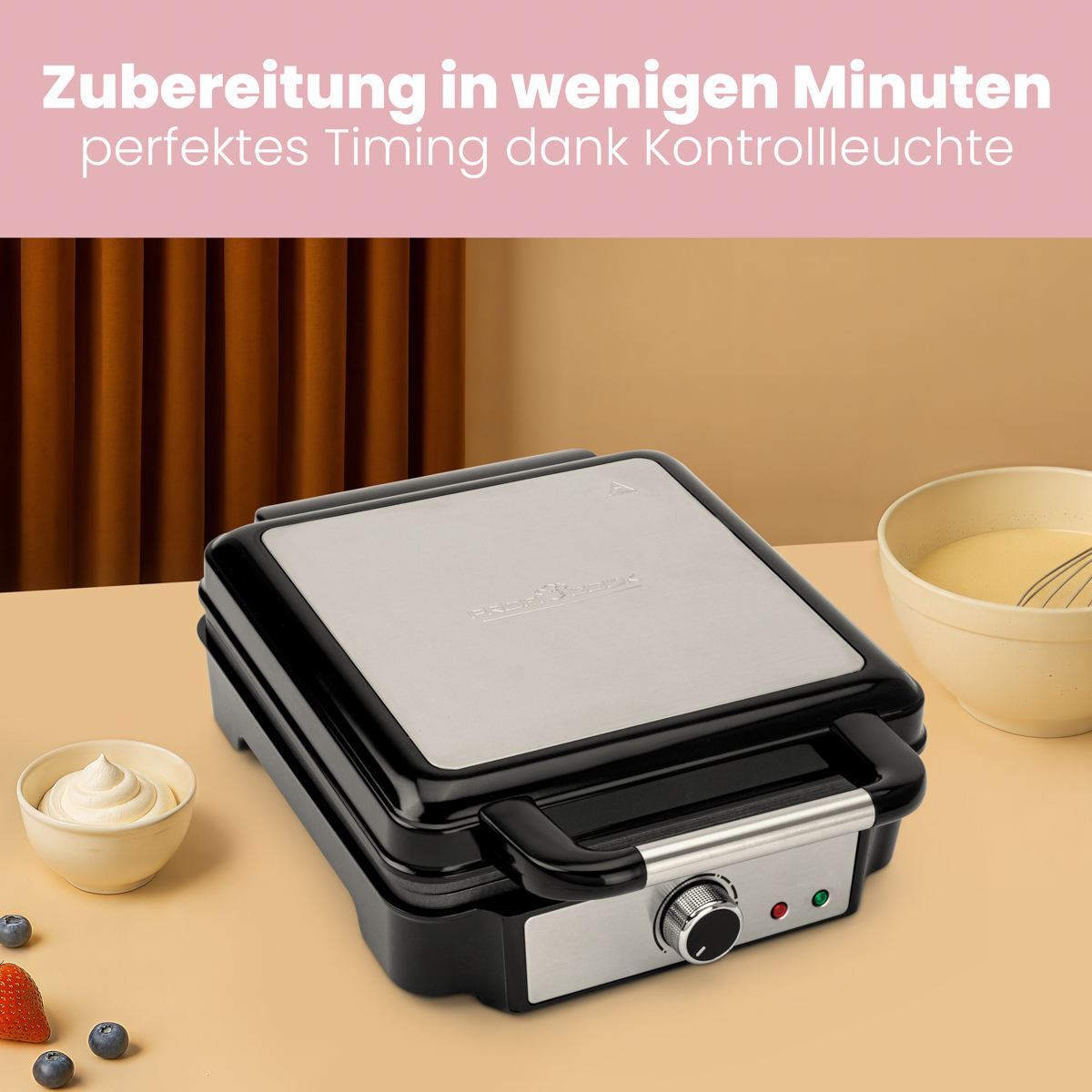 Czarny i srebrny gofrownica z tekstem powyżej. W pobliżu znajdują się małe miski i jagody.