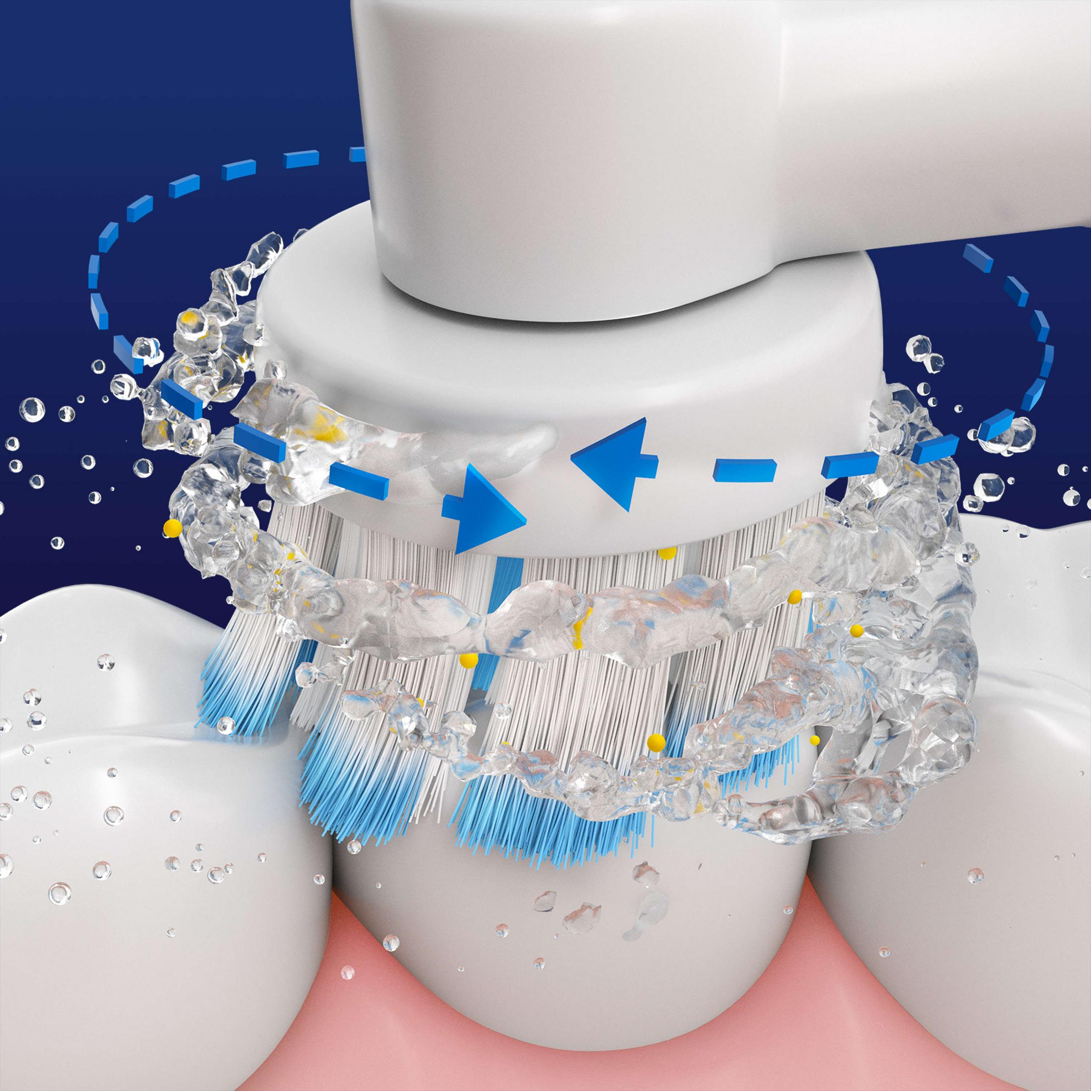 Gros plan d'une brosse à dents électrique nettoyant les dents avec des gouttelettes d'eau.