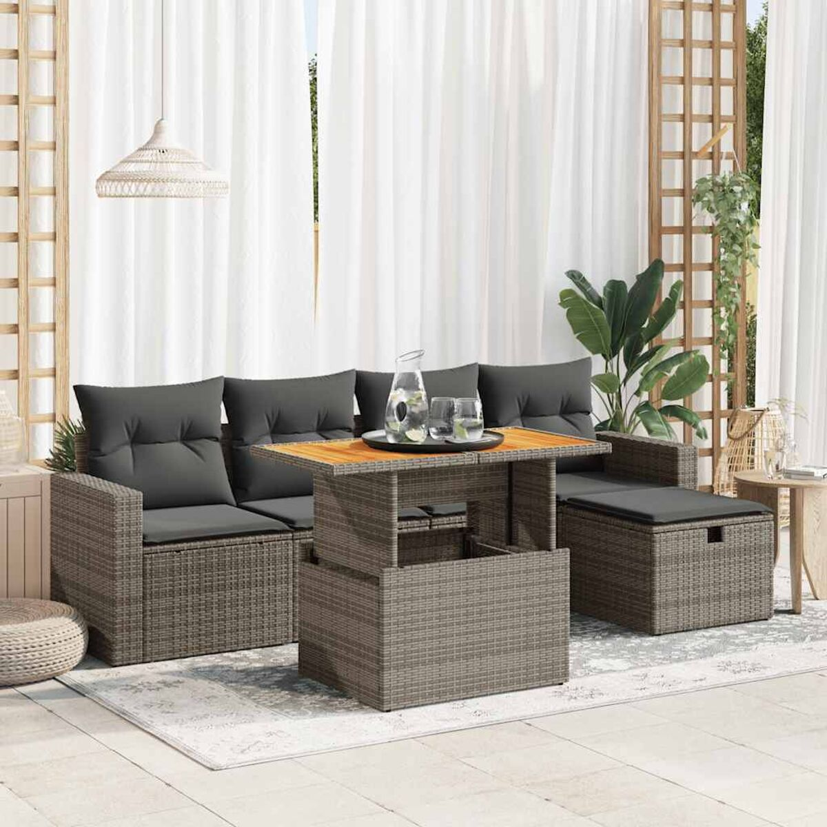 Geflochtenes Gartenmöbel-Set mit Tisch. Kissen und Vorhänge sind vorhanden.