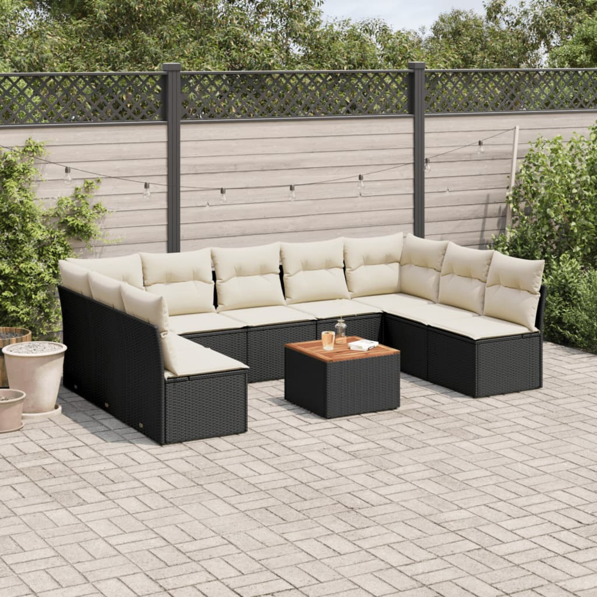Outdoor-Ecksofa-Set mit Couchtisch auf einer Terrasse. Mit beigen Kissen und einem Zaun.