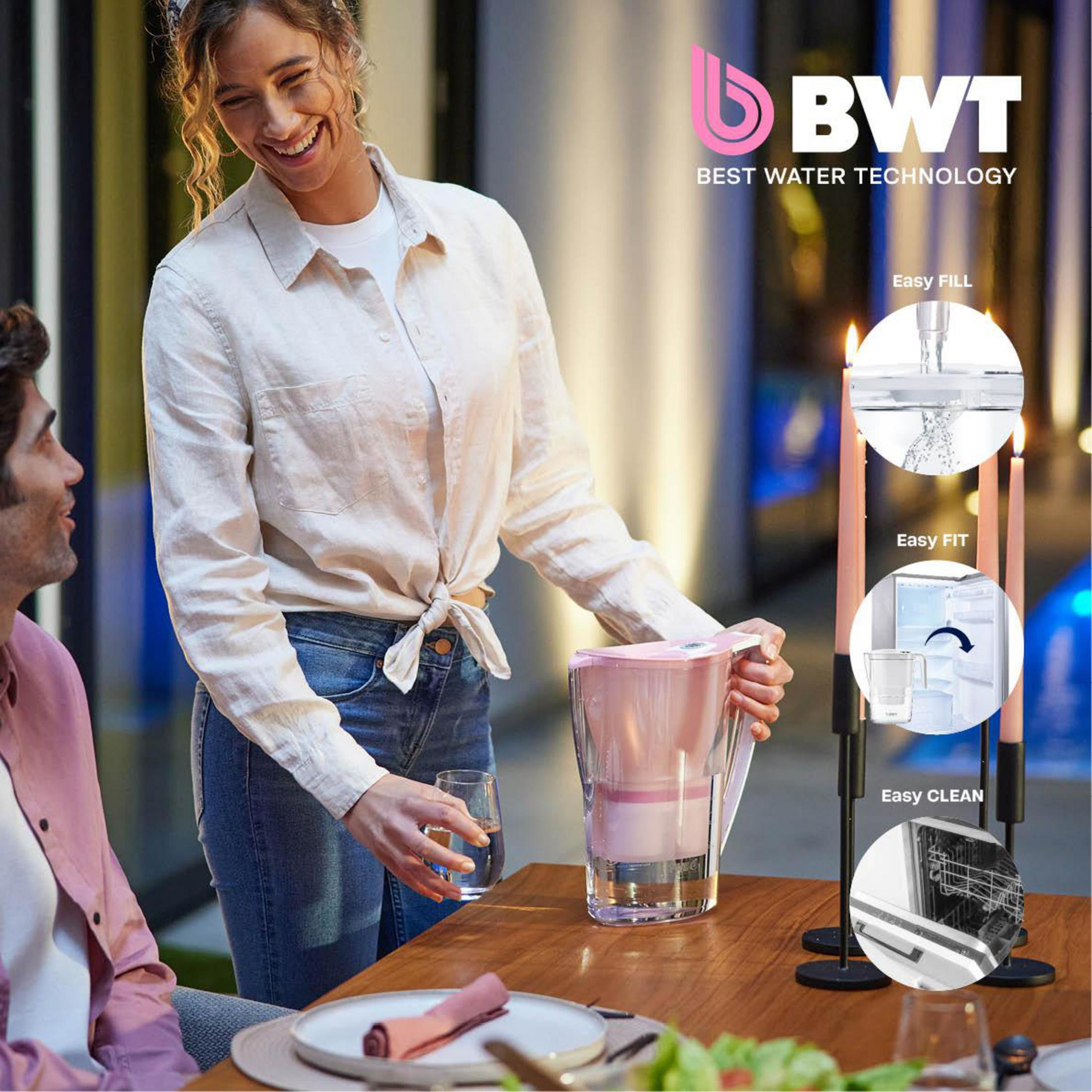 Woman holding a glass. BWT water filter system.  Candles on table.  Outdoor setting.  Smiling.