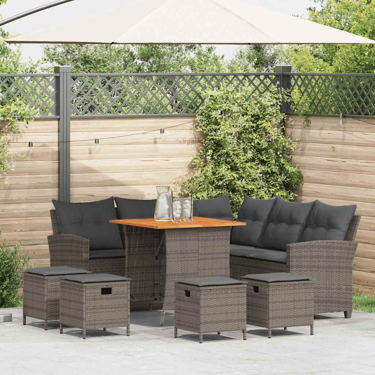 Gartenmöbel-Set: Sofa, Stühle, Tisch und Hocker. Graue Kissen, Holztisch.