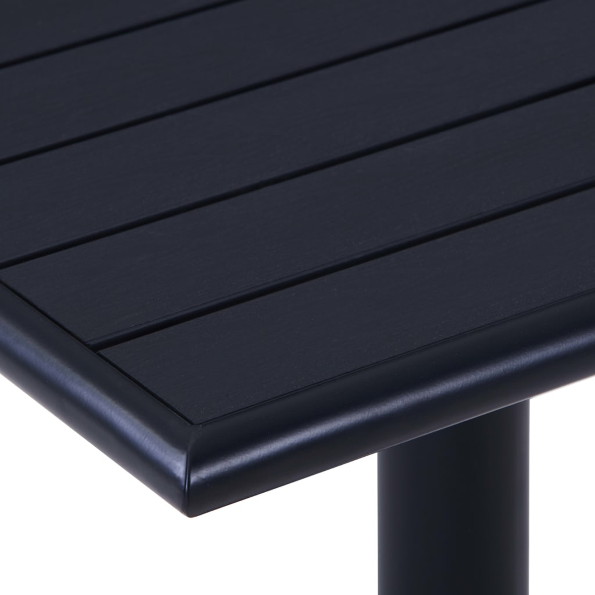 Nahaufnahme einer schwarzen Tischkante. Der Tisch hat eine dunkle Oberfläche mit horizontalen Linien und eine schwarze, abgerundete Kante.