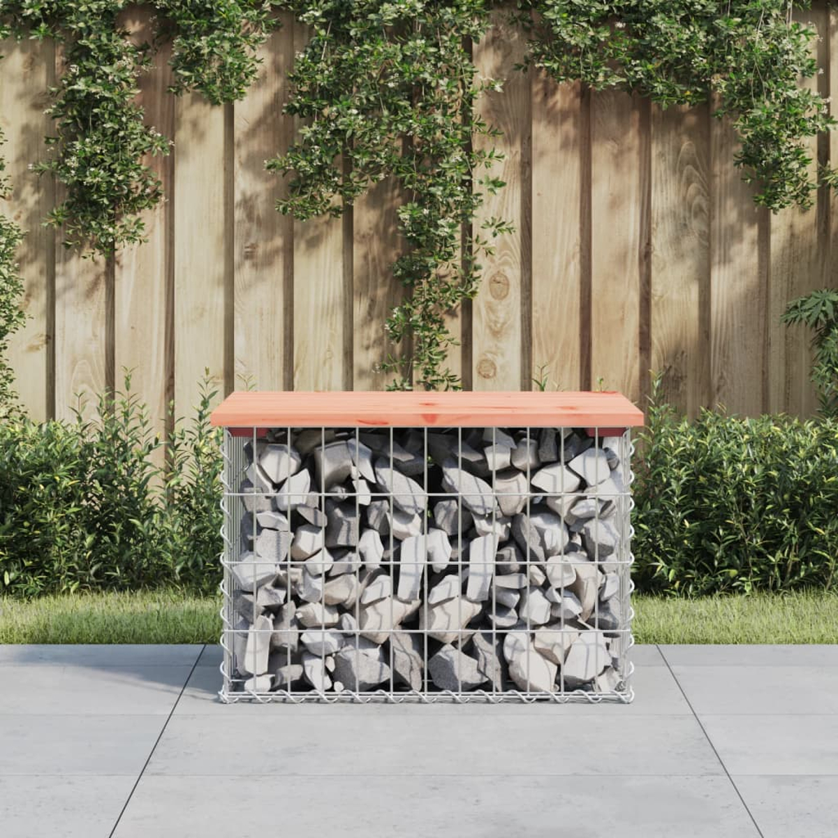 Eine Gabionenbank mit Holzplatte. Sie ist mit grauen Steinen gefüllt, in einer Gartenszene.