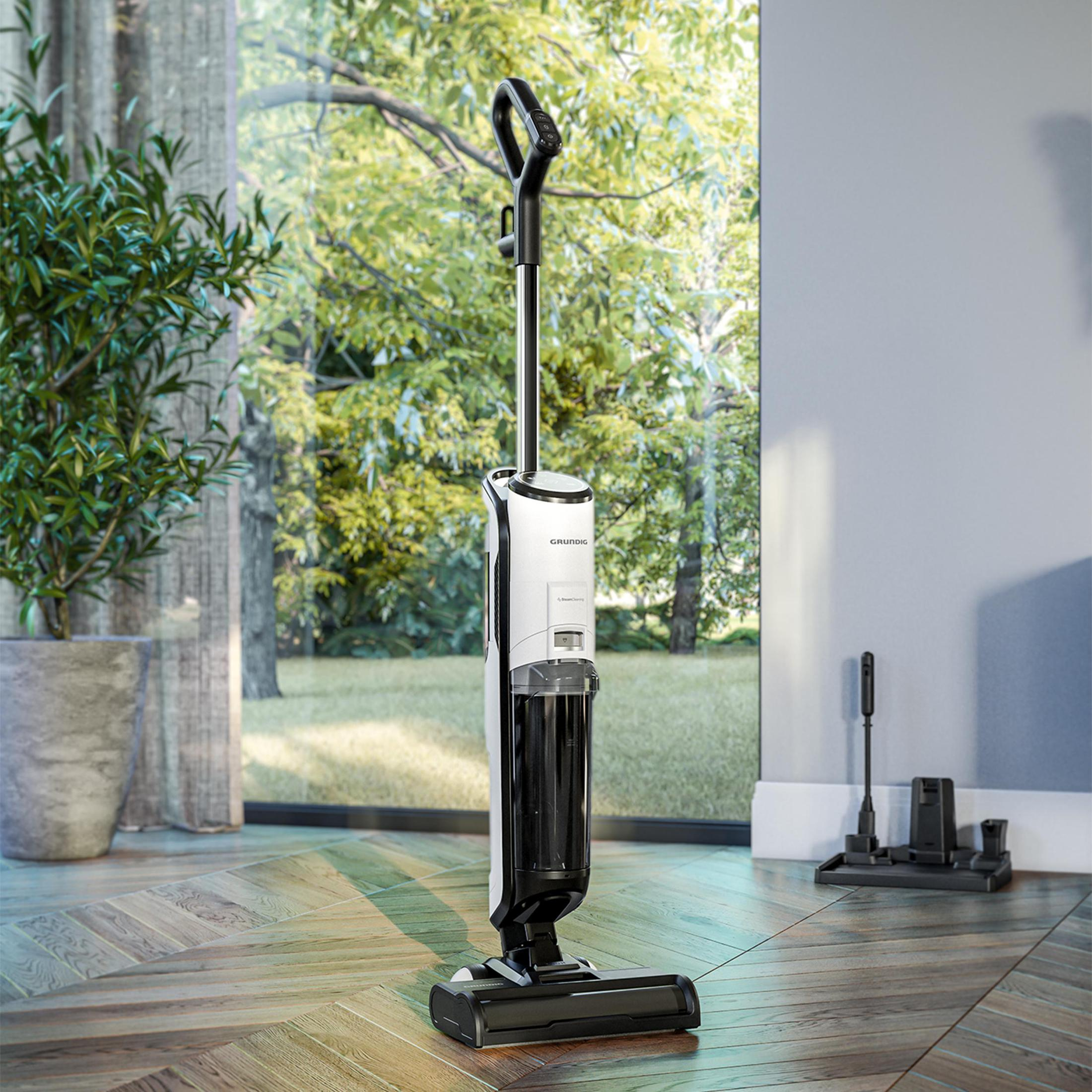 Biało-czarny odkurzacz do podłóg Grundig stojący obok okna.