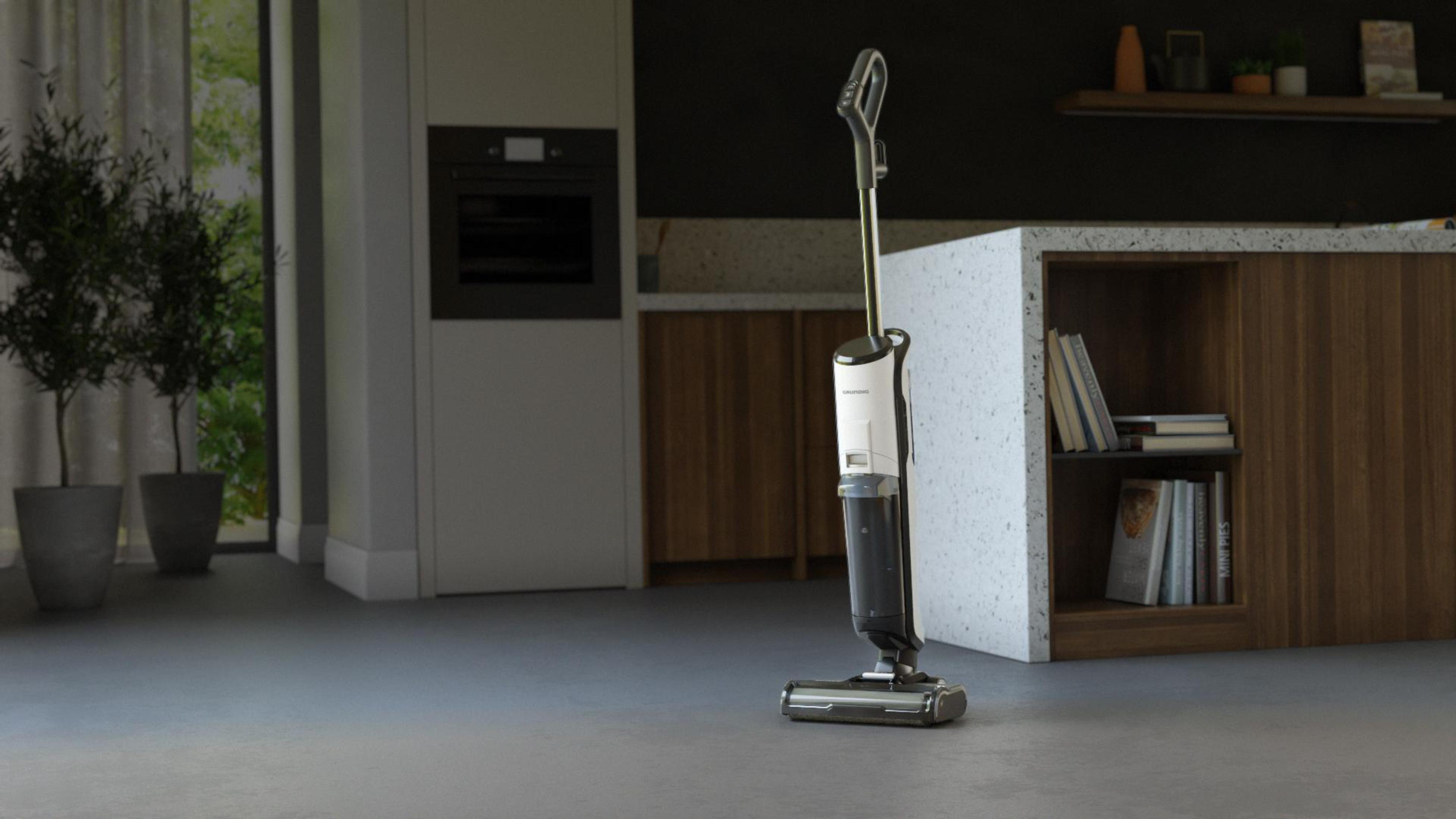 Bezprzewodowa myjka do podłóg w nowoczesnej kuchni. Ciemne szafki i biała ściana.