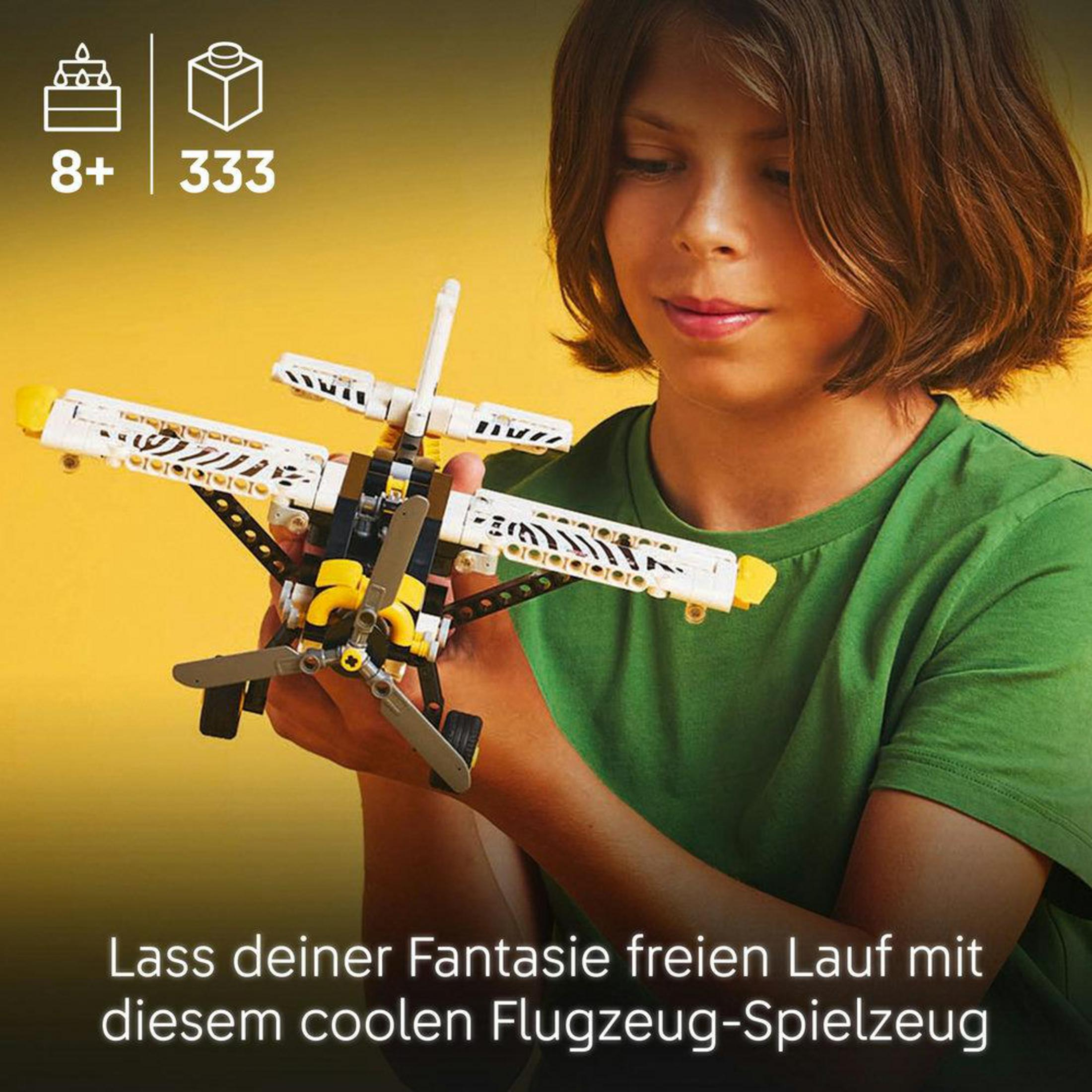 Niño sosteniendo un avión Lego. Tiene alas blancas y detalles amarillos.