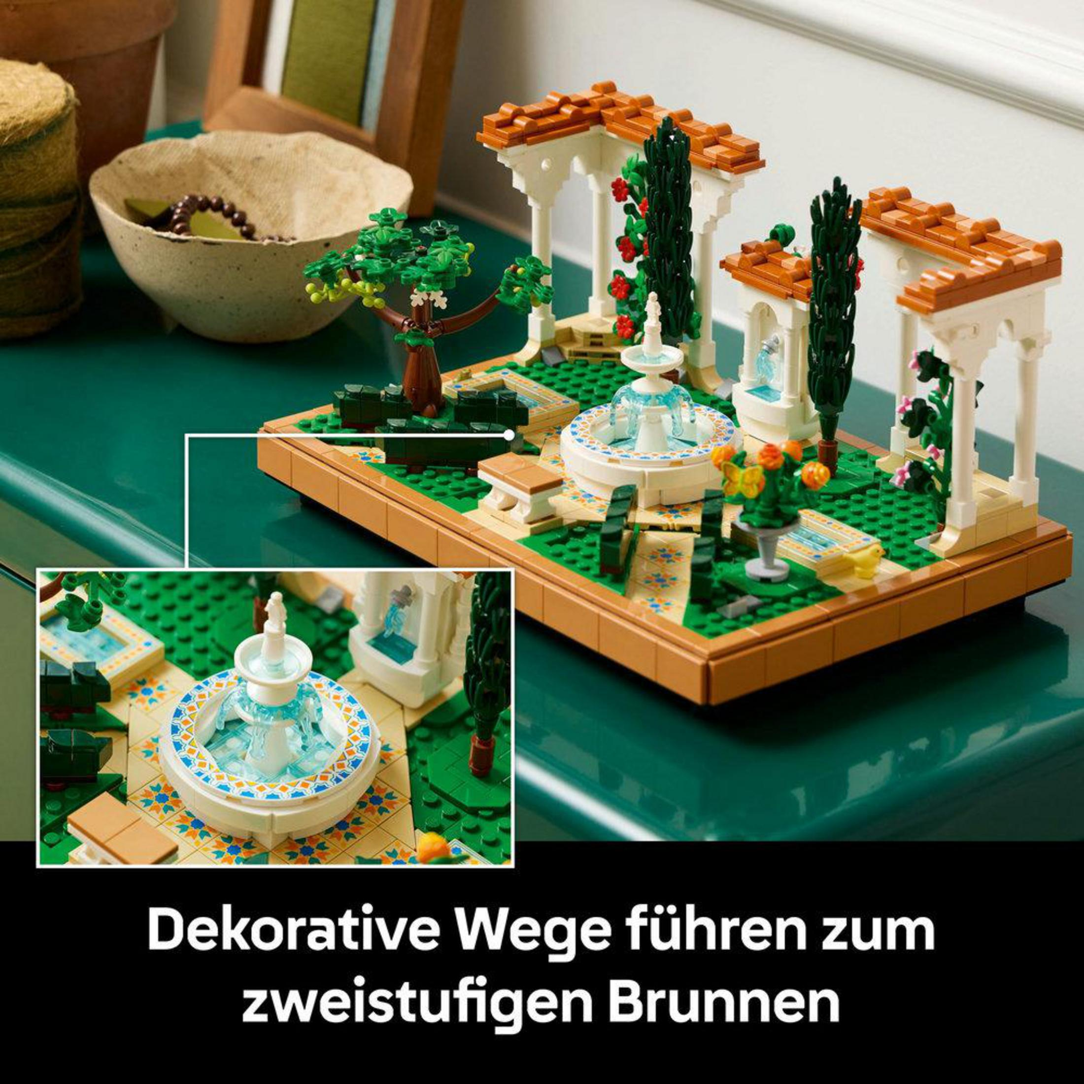 Un diorama LEGO de un jardín con una fuente y dos pequeños edificios.