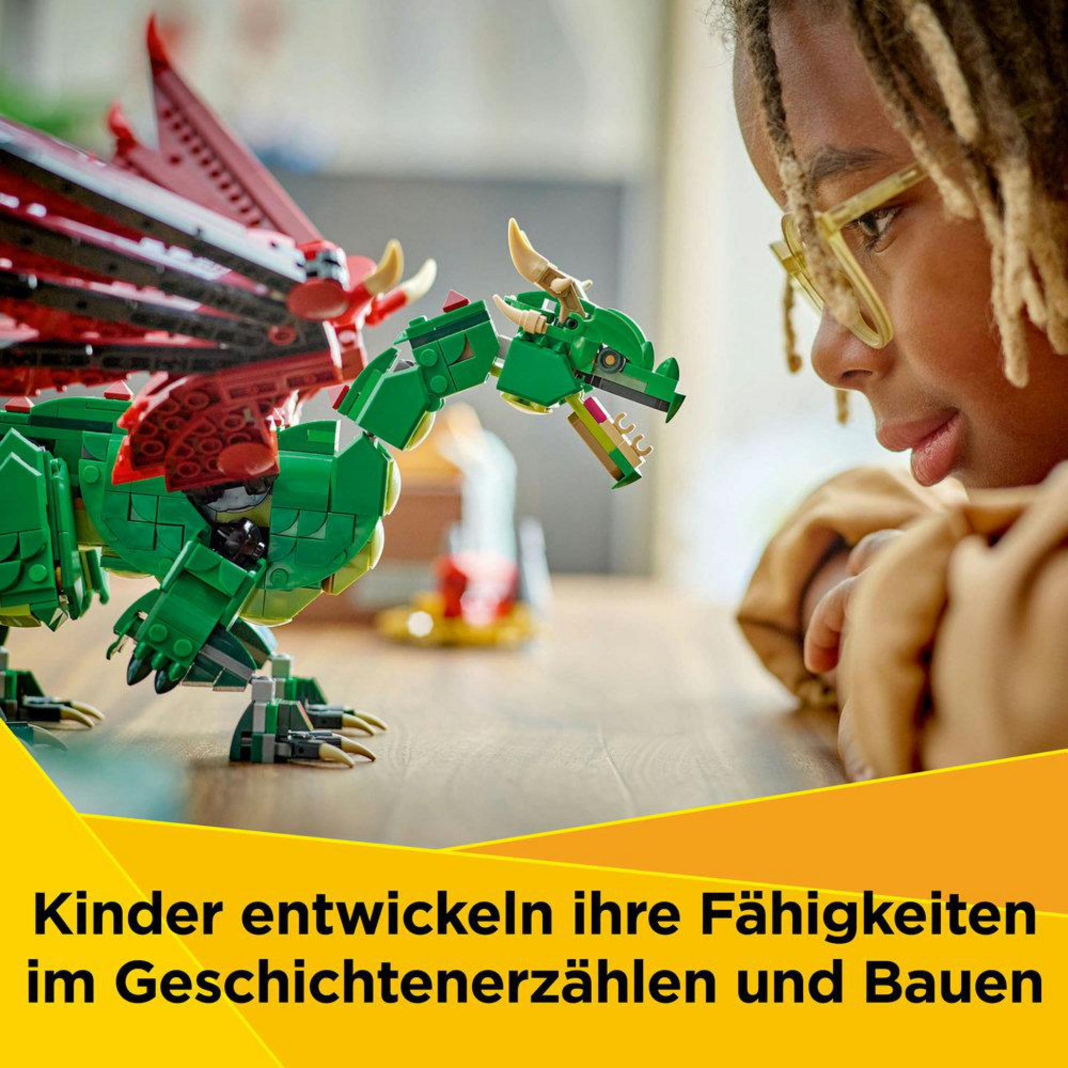 Dziecko patrzy na zielonego smoka Lego. Smok ma czerwone skrzydła i stoi na drewnianej powierzchni.