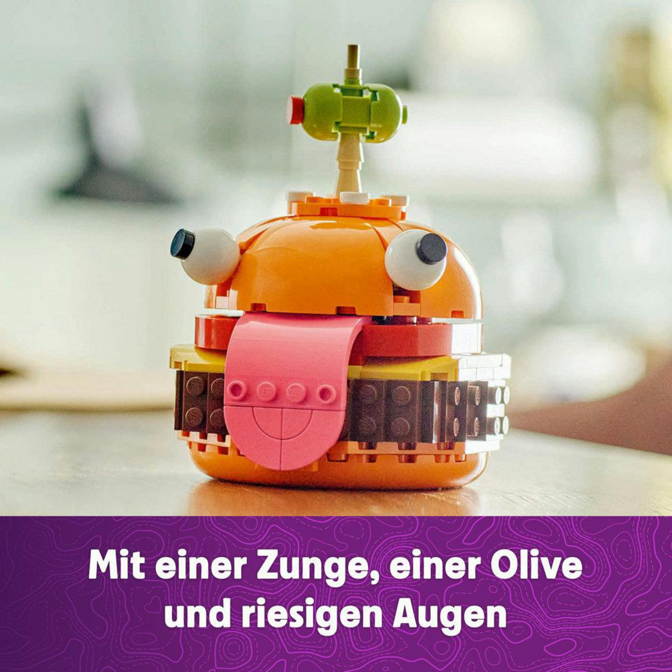 Ein Lego-Set zeigt einen Burger mit Zunge, Olive und großen Kulleraugen.