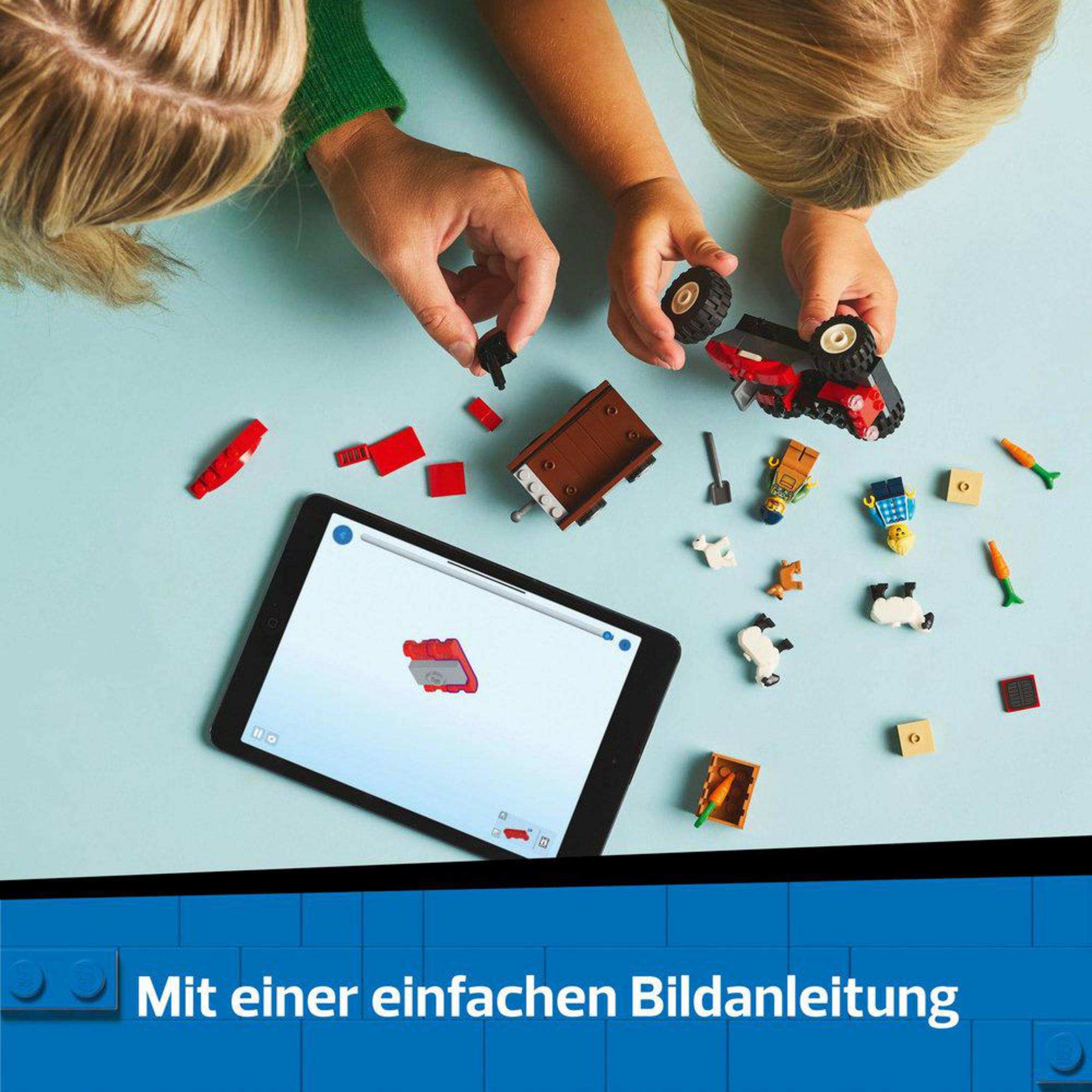 Hände montieren Lego-Teile, ein Tablet zeigt Bauanleitungen.