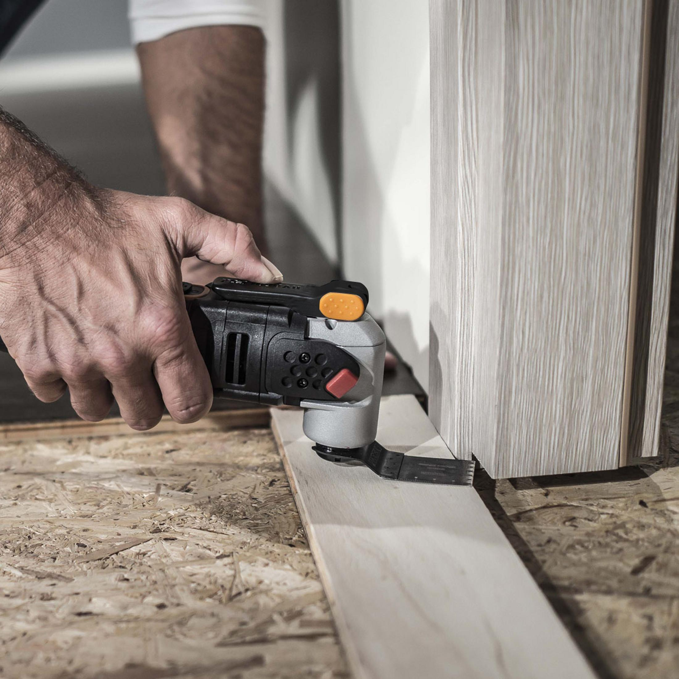 Osoba używająca elektronarzędzia do cięcia drewna. Narzędzie jest przy drewnianej ościeżnicy.
