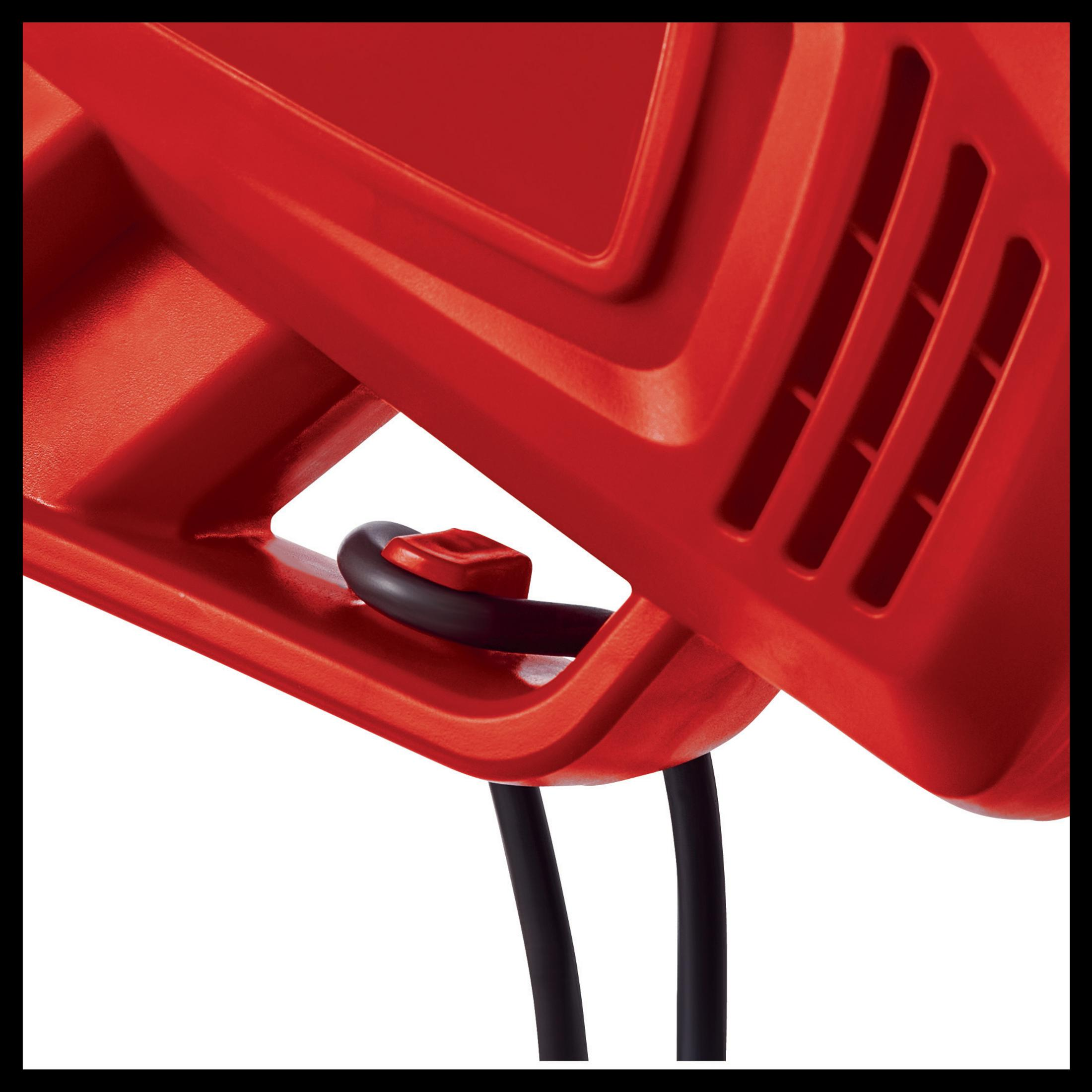 Zbliżenie czerwonego plastikowego narzędzia z czarnym przewodem i uchwytem.