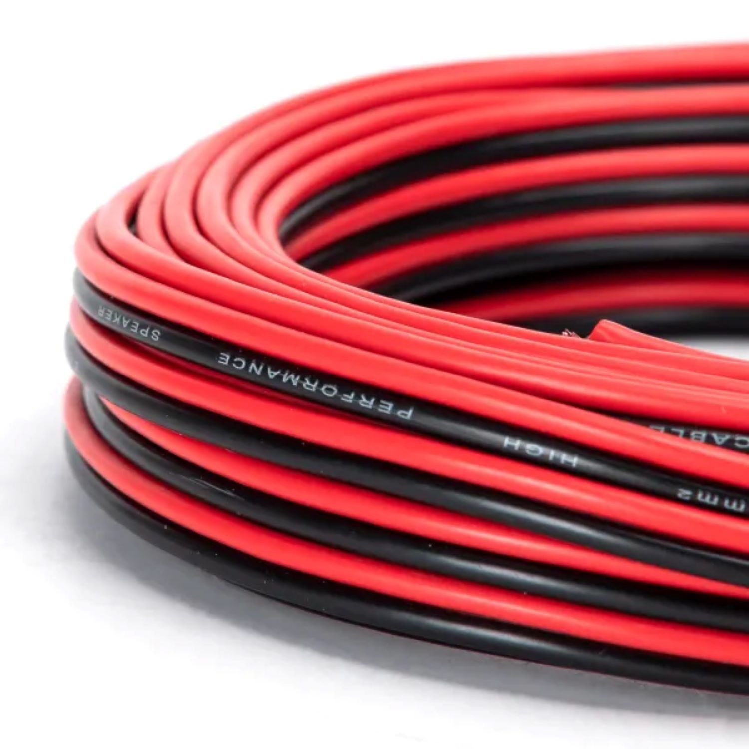 Cewka czerwono-czarnego kabla głośnikowego na białym tle, zbliżenie.