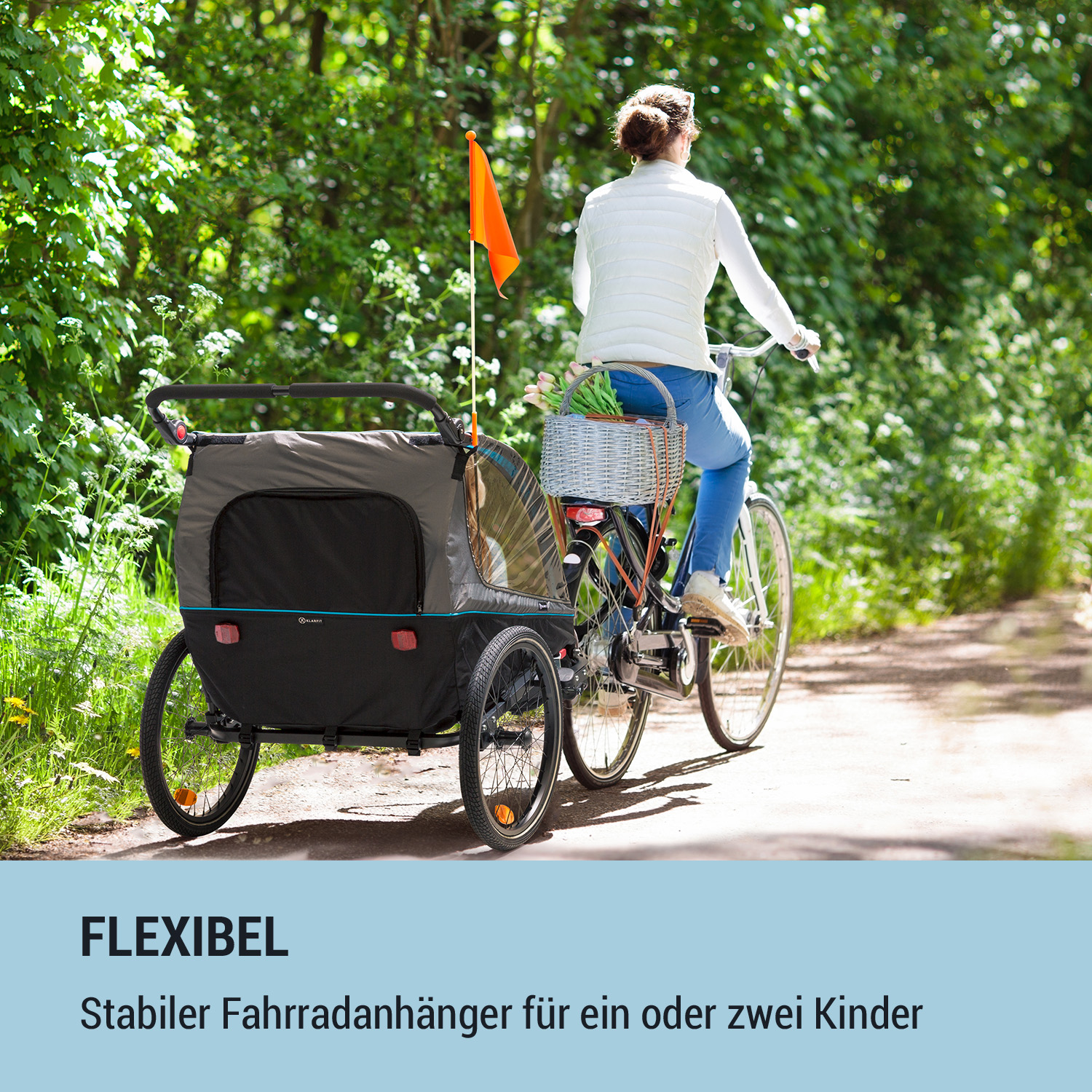 Eine Person auf einem Fahrrad, das einen Anhänger mit Korb und orangefarbener Flagge zieht.