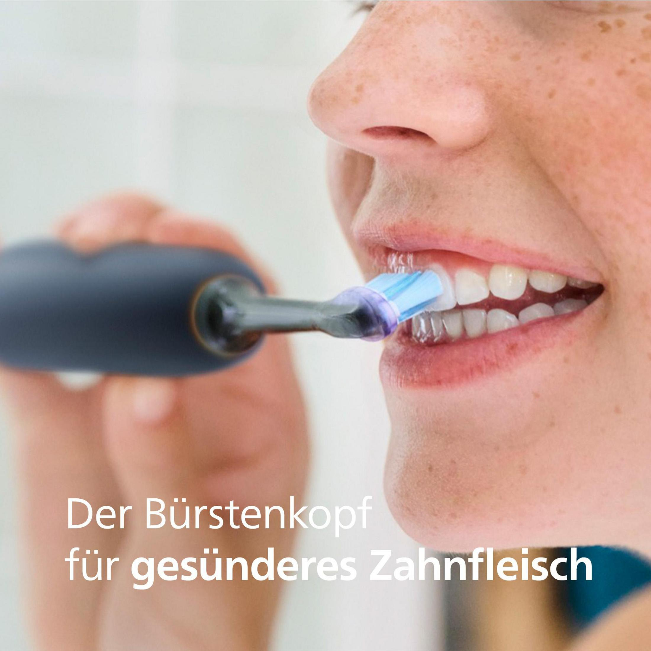 A person brushing their teeth with an electric toothbrush. The text says, "The brush head for healthier gums."
