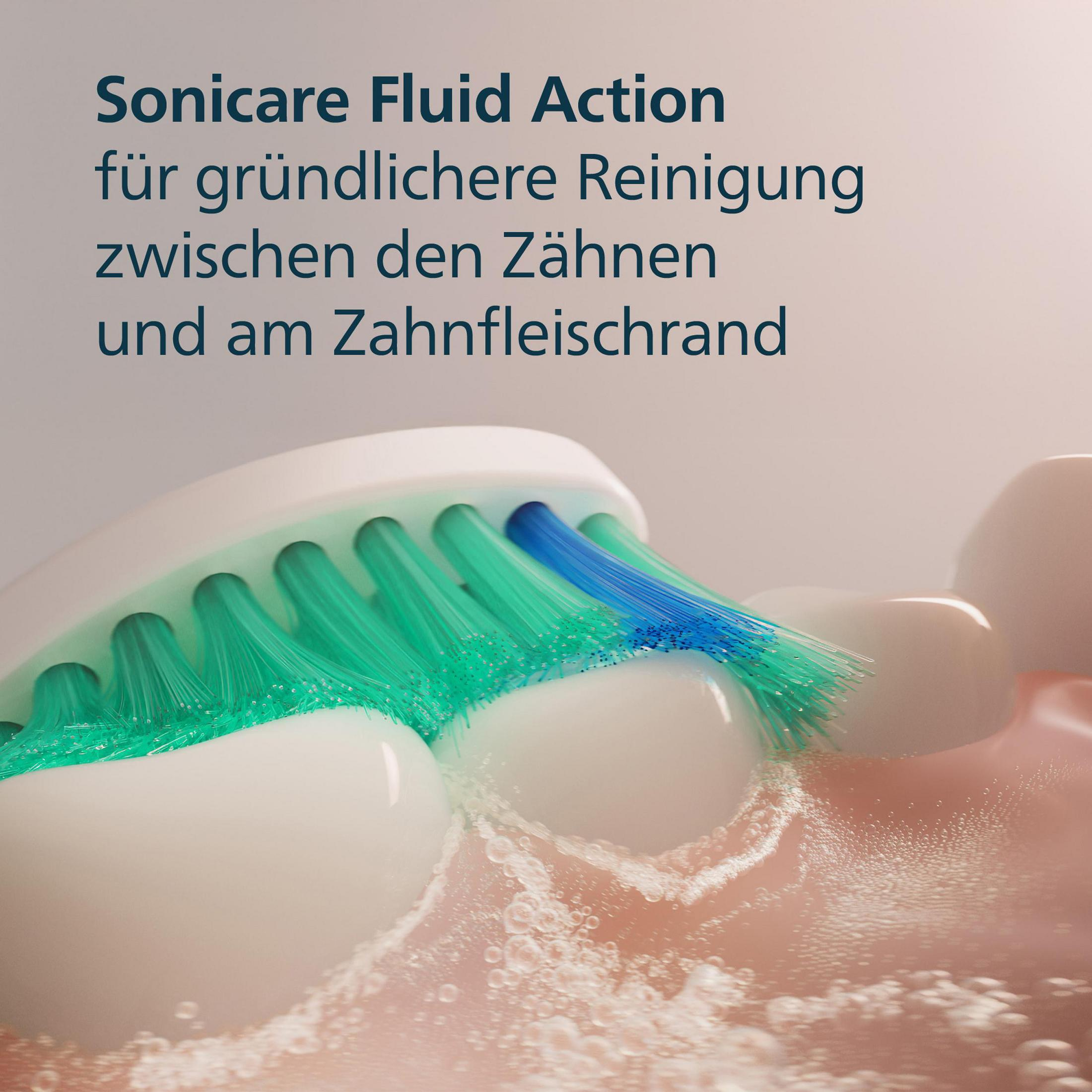 Zbliżenie szczoteczki do zębów czyszczącej zęby, z tekstem: Sonicare Fluid Action.