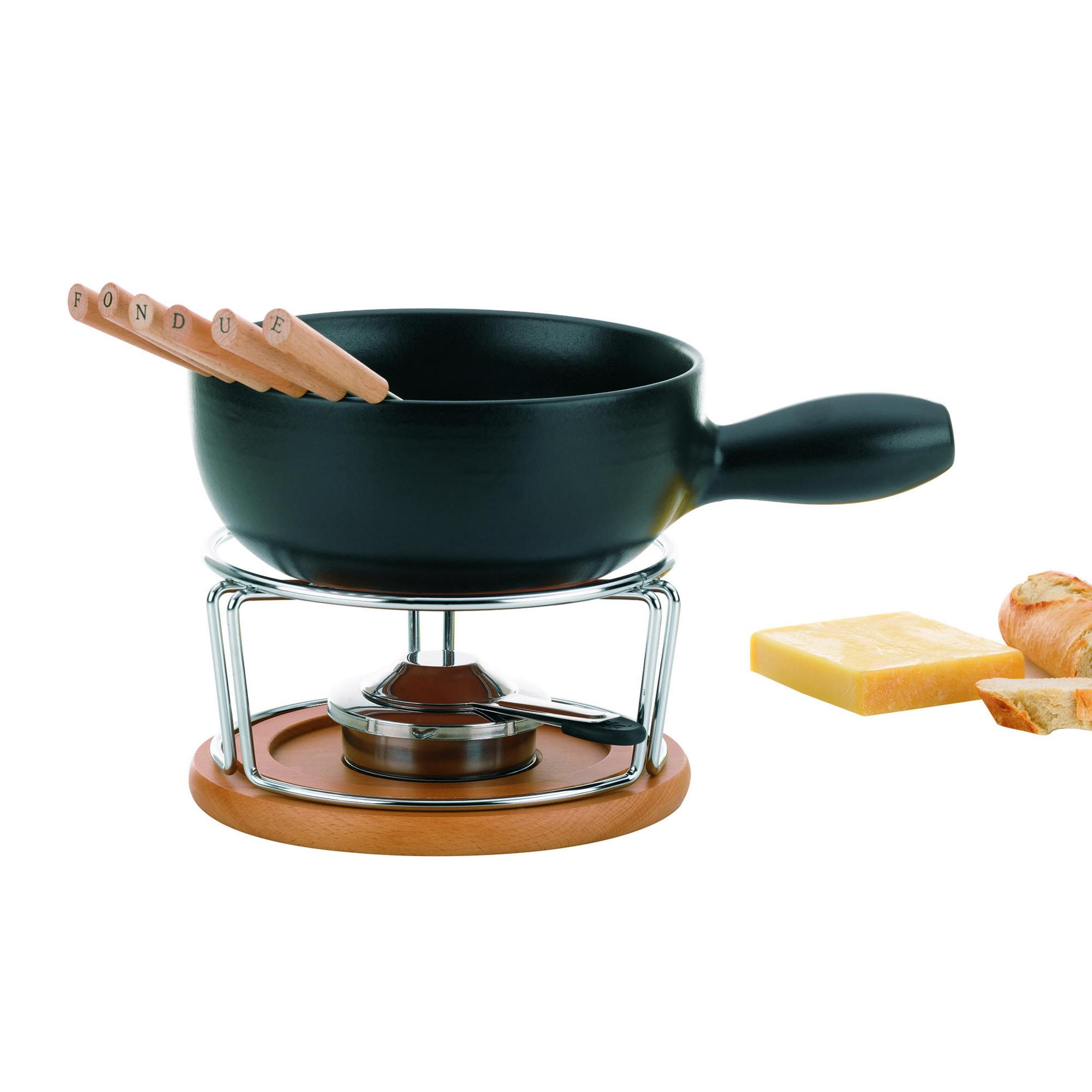 Zestaw do fondue z czarnym garnkiem, drewnianą podstawą i chlebem na białym tle.