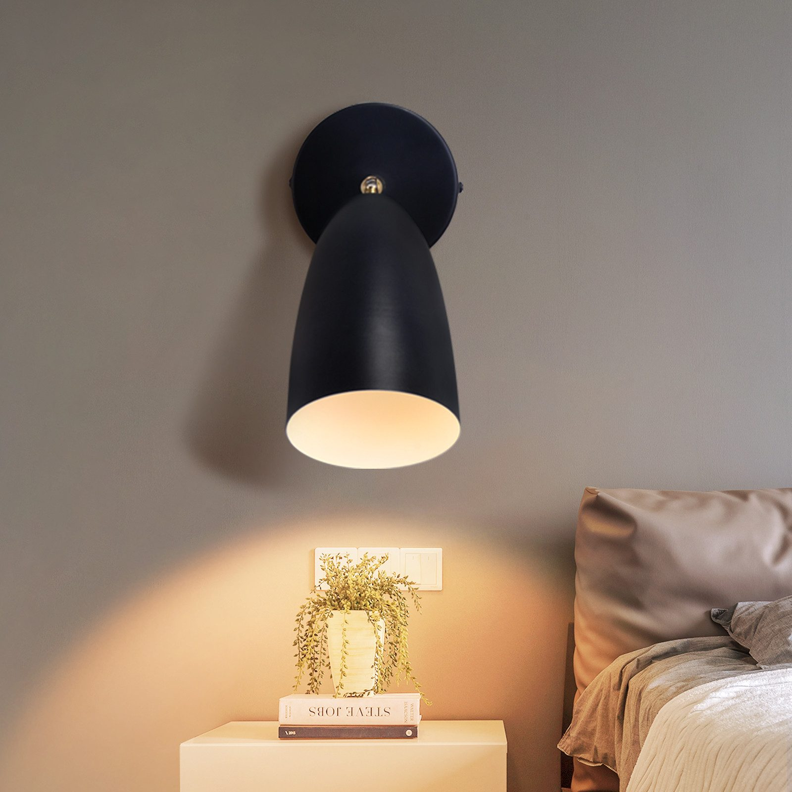 Lámpara de pared negra con luz enfocada en una mesita de noche.