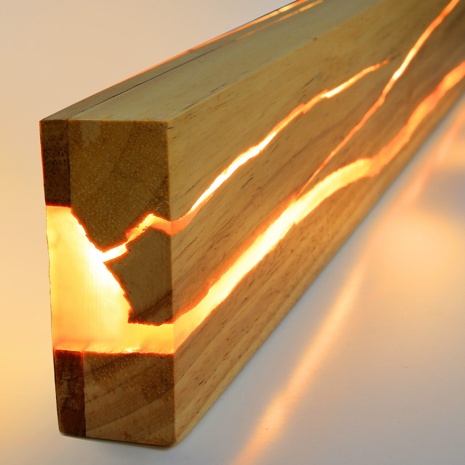 Bloque de madera con caminos de resina iluminados. La luz cálida brilla a través de la madera.