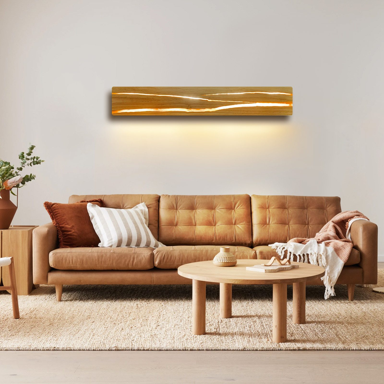 Salón con sofá de cuero, lámpara de pared de madera, alfombra y mesa auxiliar.