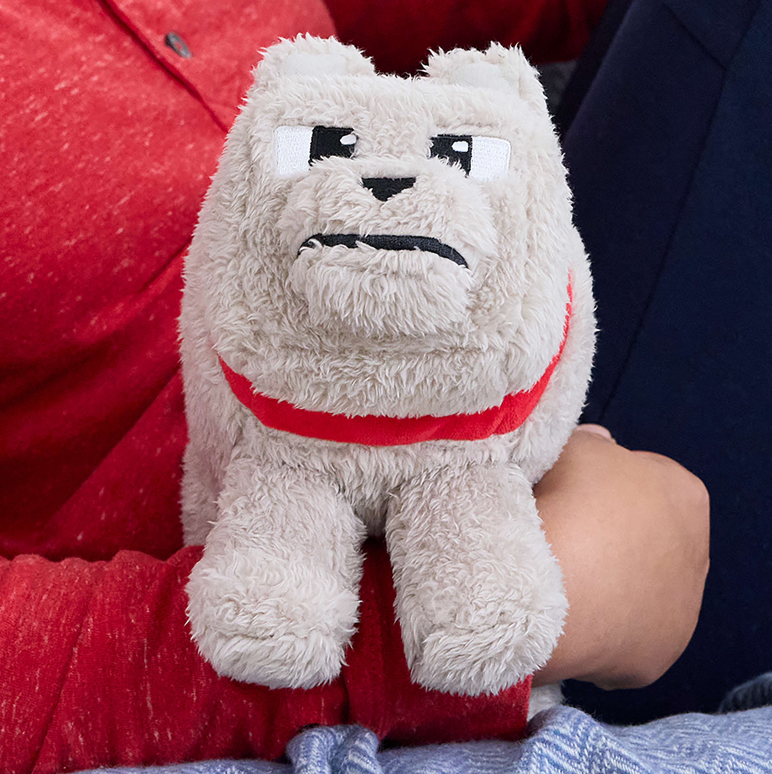 Peluche di cane Minecraft bianco con collare rosso, tenuto da una persona con una camicia rossa.