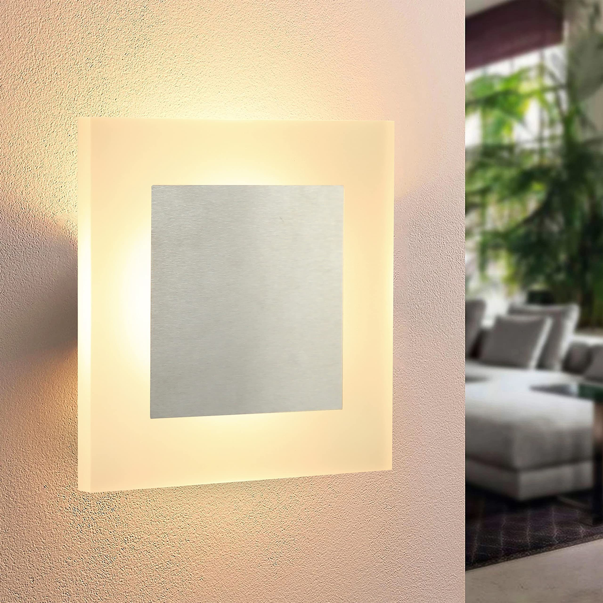 Luz de pared moderna, forma cuadrada con un cuadrado plateado en el centro. Interior.