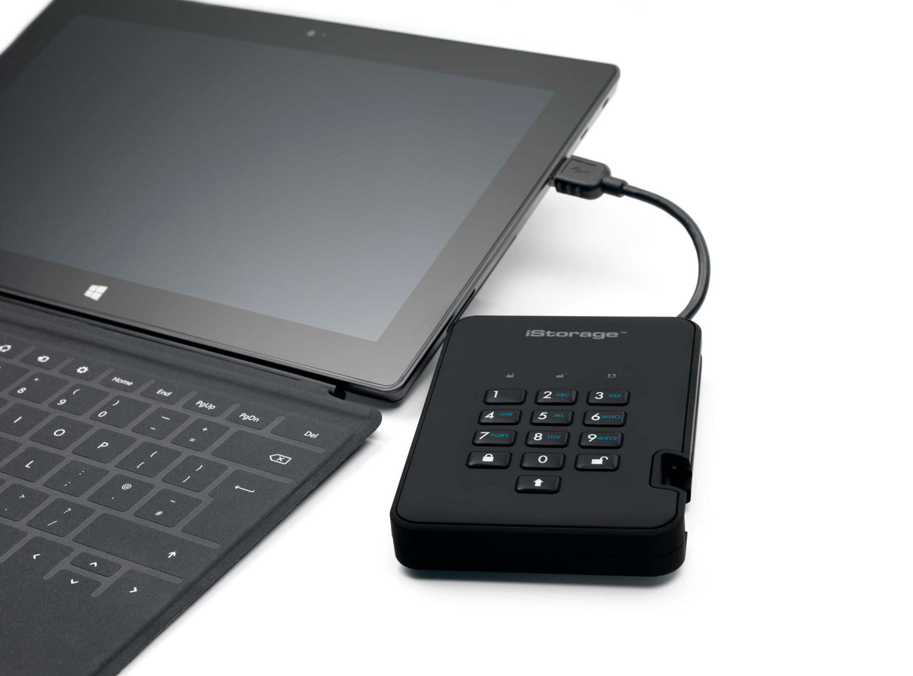 Tablet über ein USB-Kabel mit einem schwarzen iStorage-Gerät verbunden. Die Tastatur ist sichtbar.