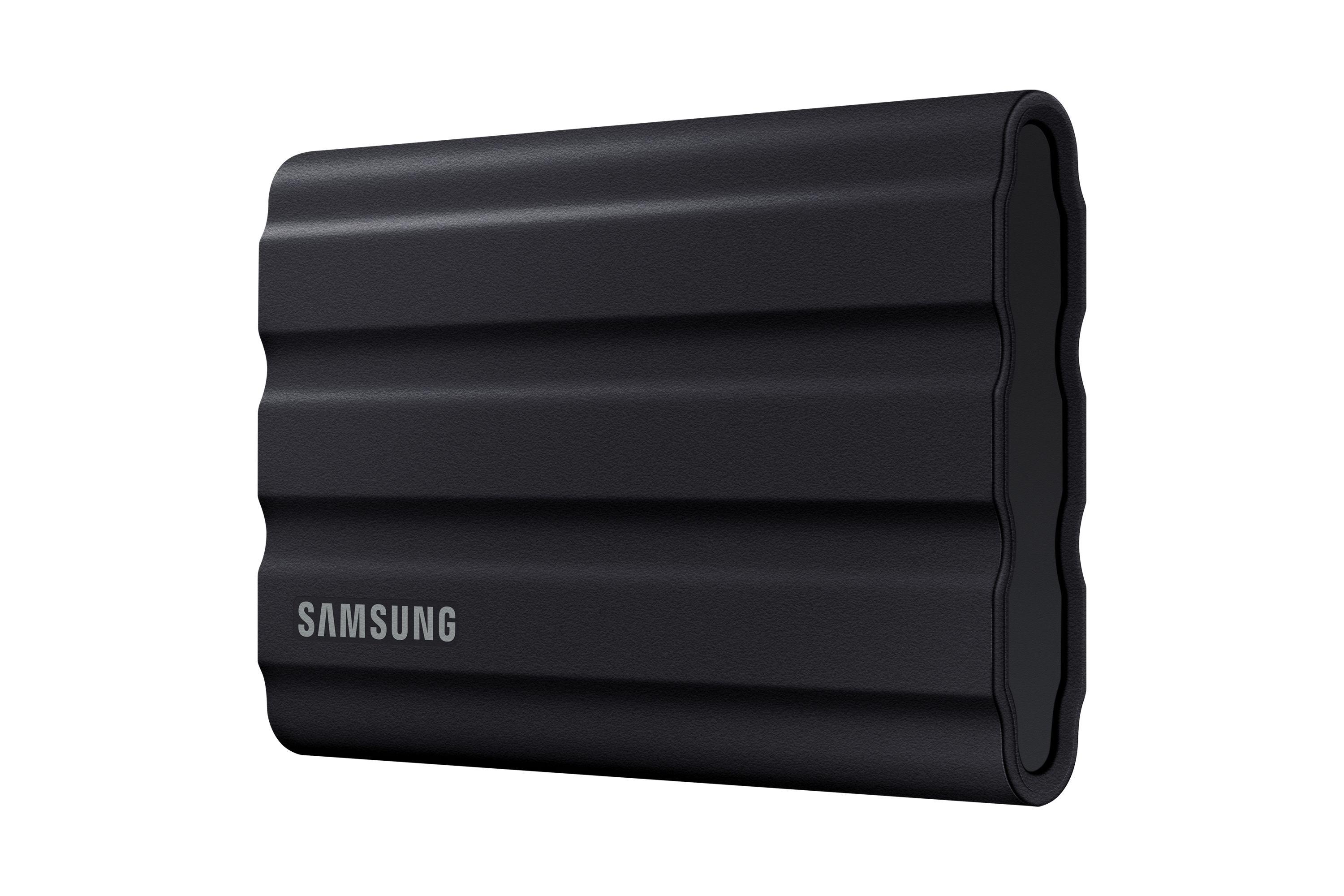 Black Samsung external hard drive. It has a ridged surface and the brand name. White background.
