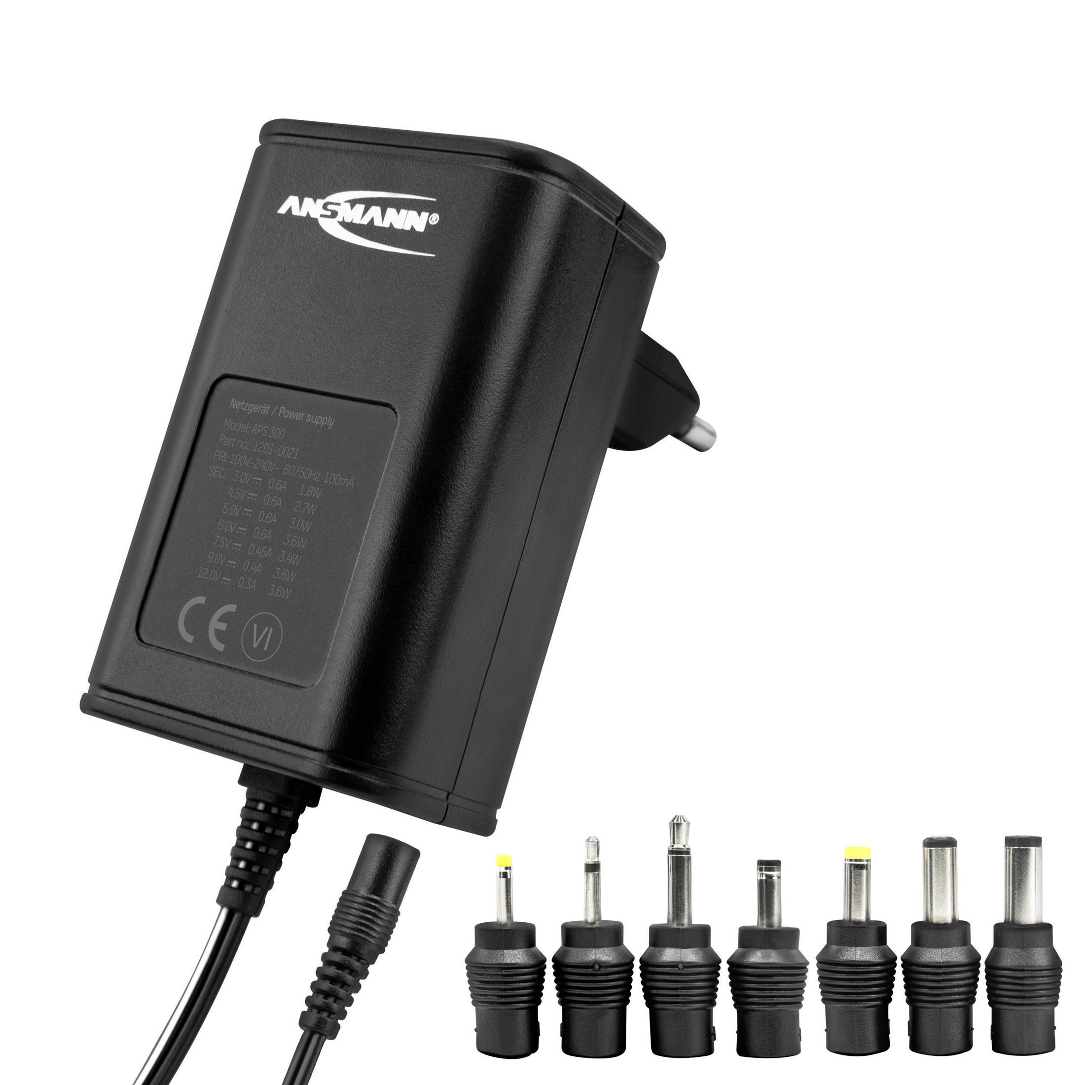 Czarny zasilacz Ansmann z wieloma głowicami adapterów na białym tle. Kable i wtyczka również widoczne.
