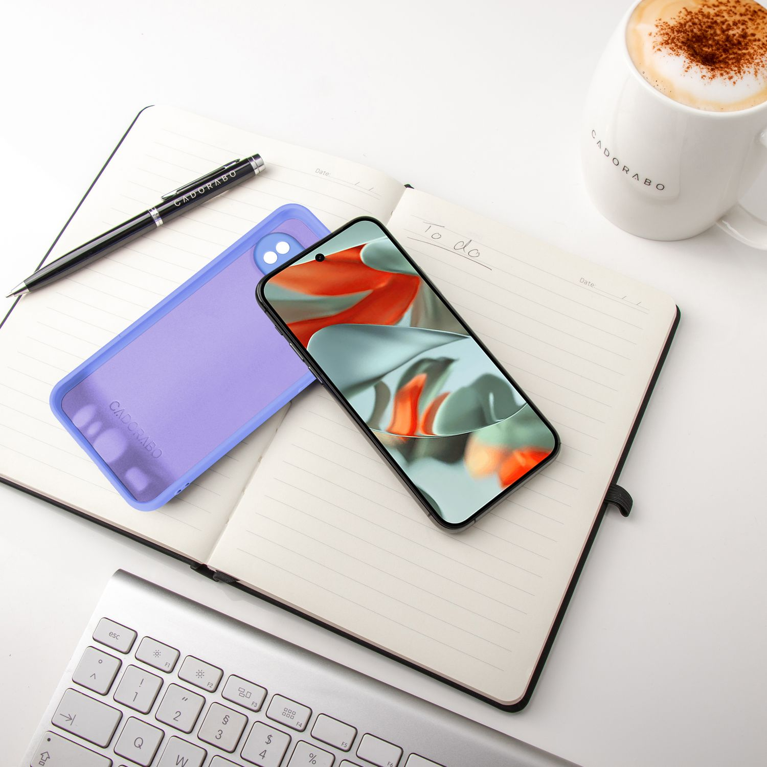 Telefon in blauer Hülle auf einem Notizbuch. Stift und eine Tasse Kaffee auf dem Tisch. Weißer Hintergrund.