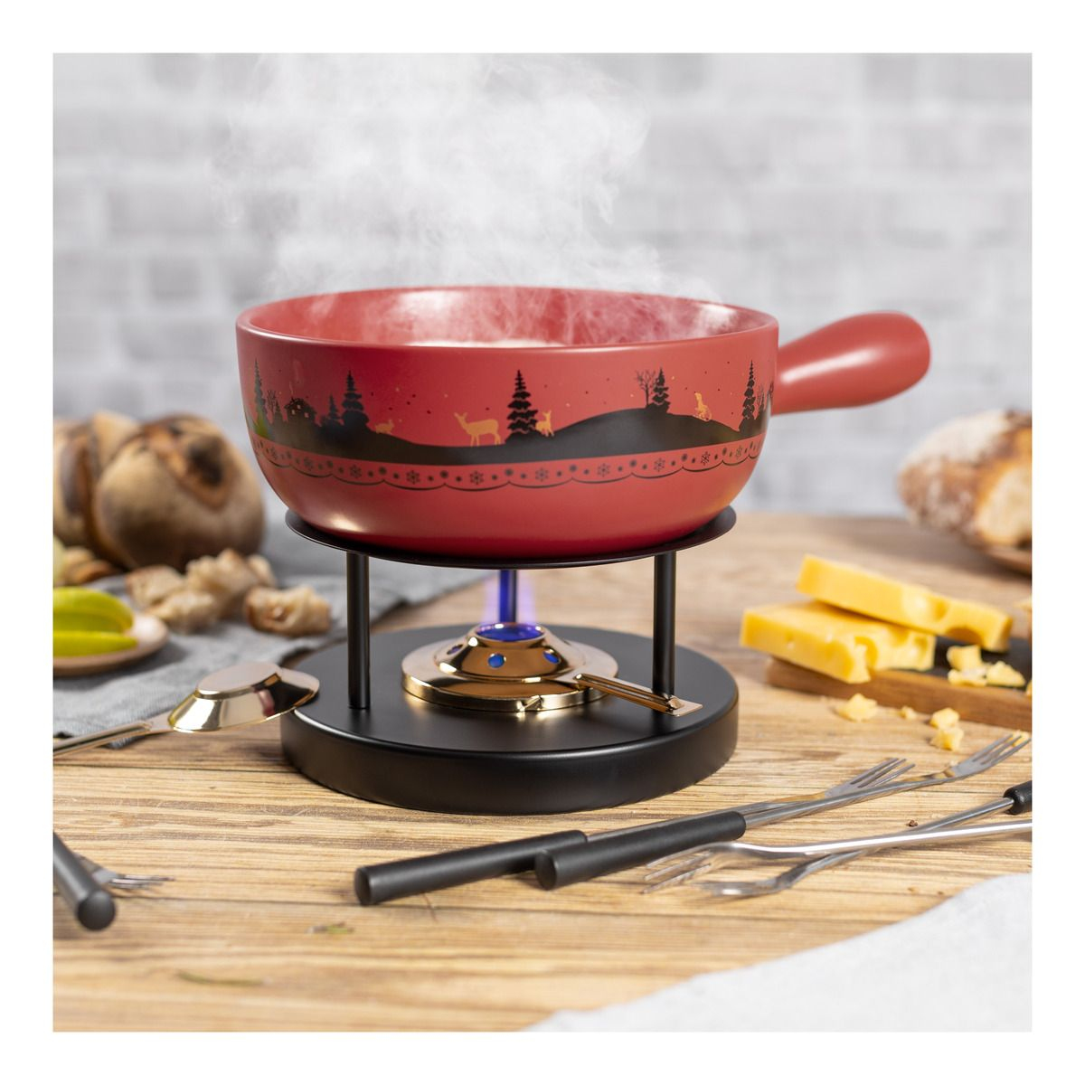 Ein roter Fonduetopf, dampfend, über einer Flamme, mit Käse, Brot und Gabeln auf einem Holztisch.