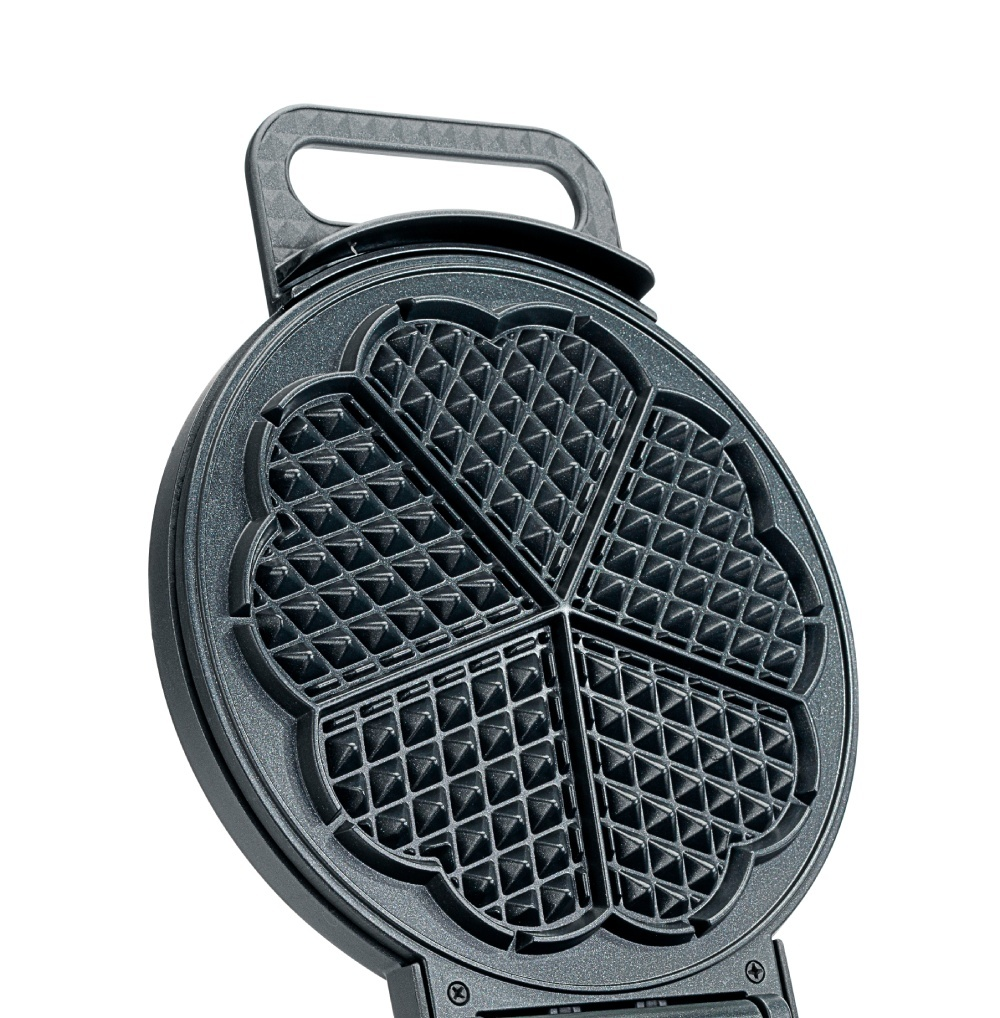Schwarzer Waffeleisen, geöffnet, zeigt vier herzförmige Waffelabschnitte. Nahaufnahme.