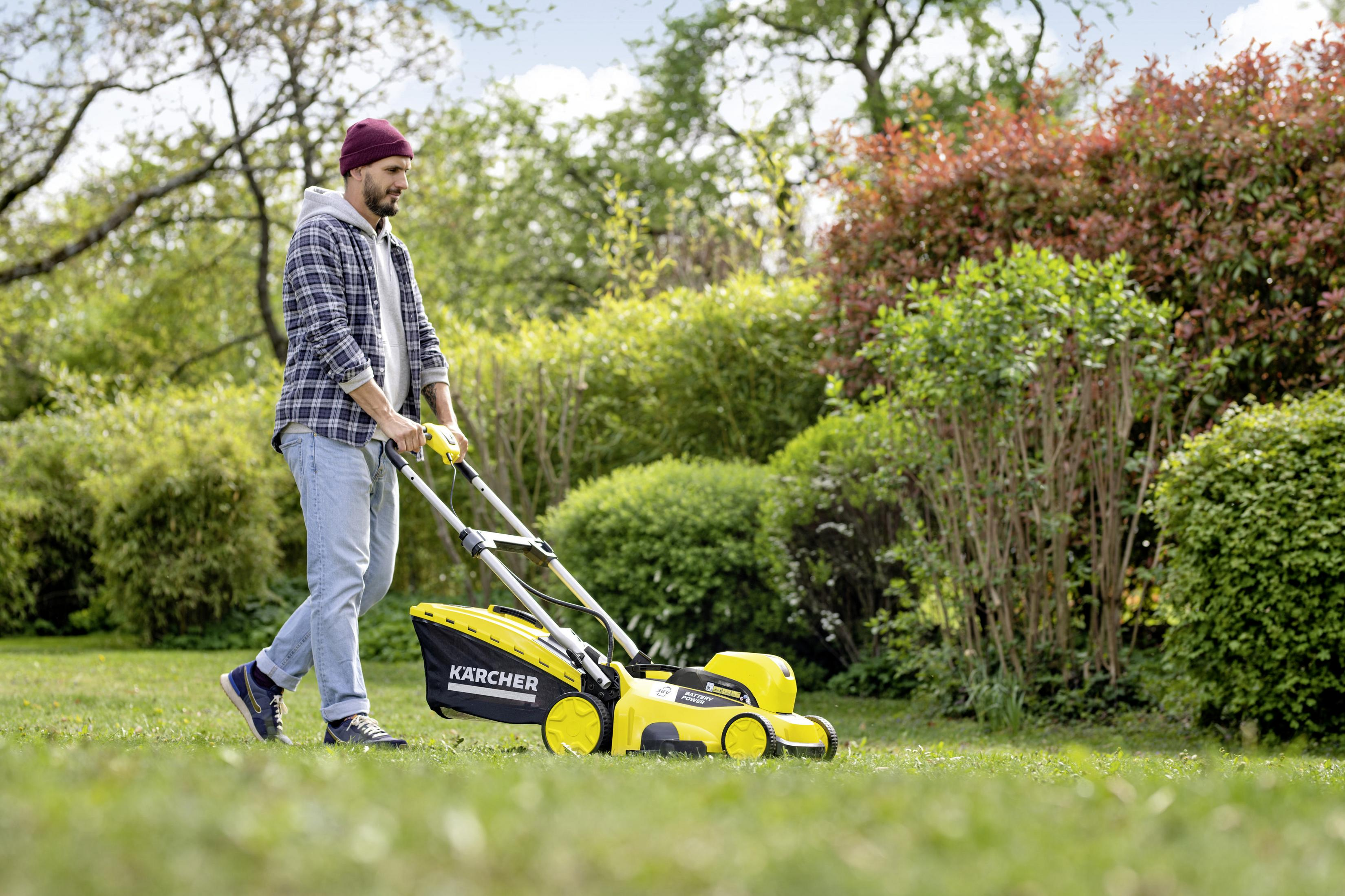 Hombre cortando el césped con un cortacésped amarillo y negro. La hierba es verde.