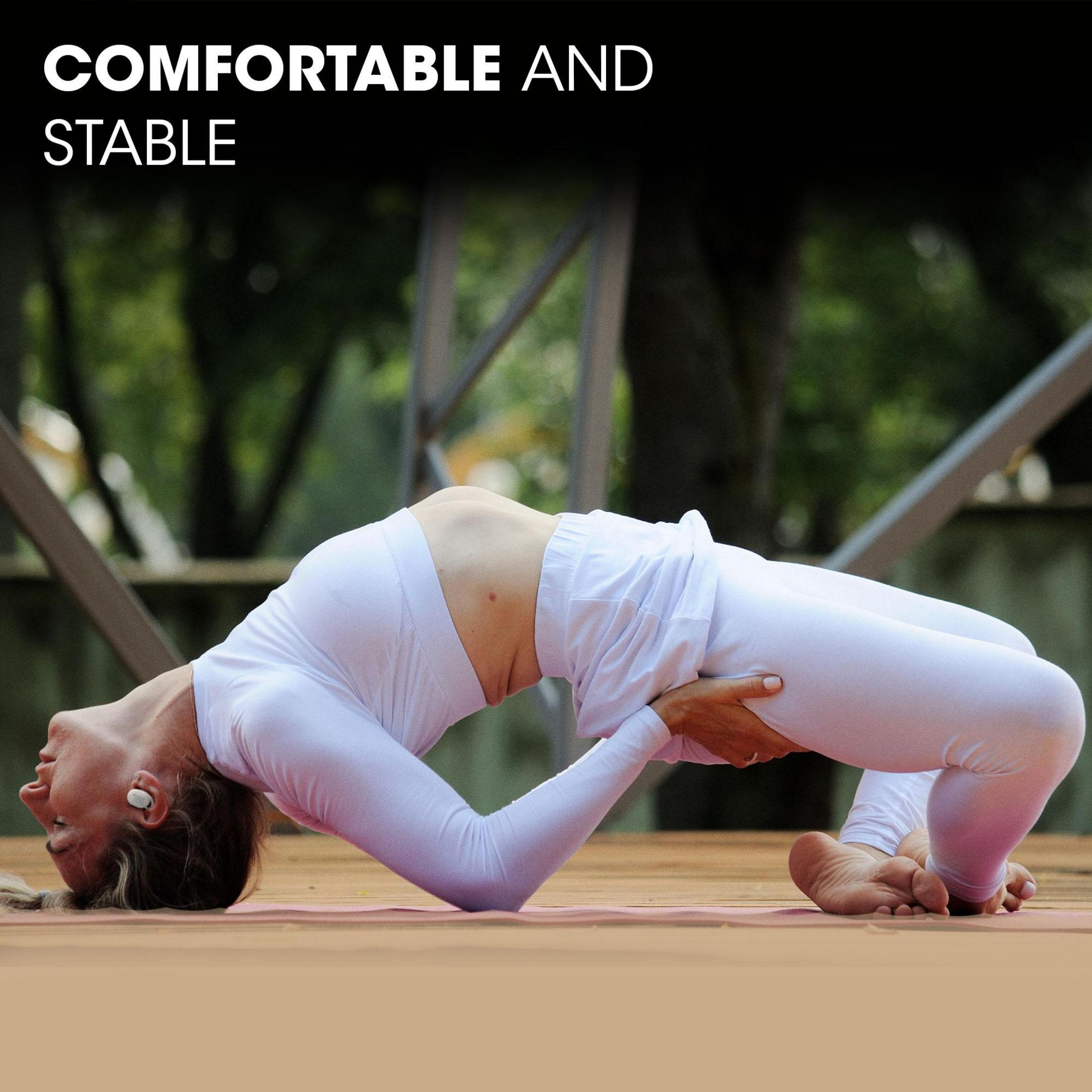 Kobieta uprawiająca jogę, wygięte plecy. Ma na sobie białe ubrania i pojawia się tekst 'WYGODNE I STABILNE'.