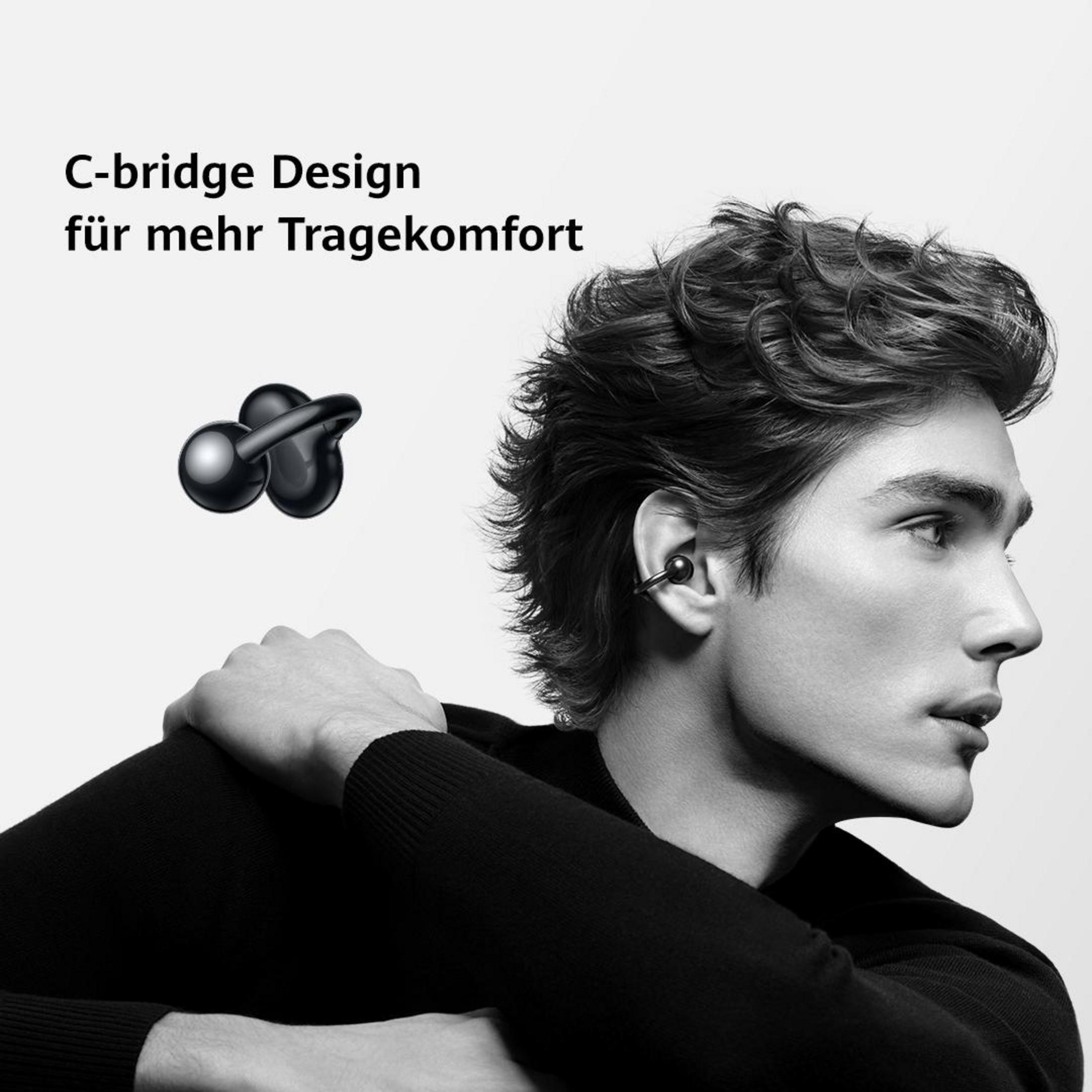 Mężczyzna ze słuchawkami w uchu, czarny, z tekstem C-bridge Design, na białym.