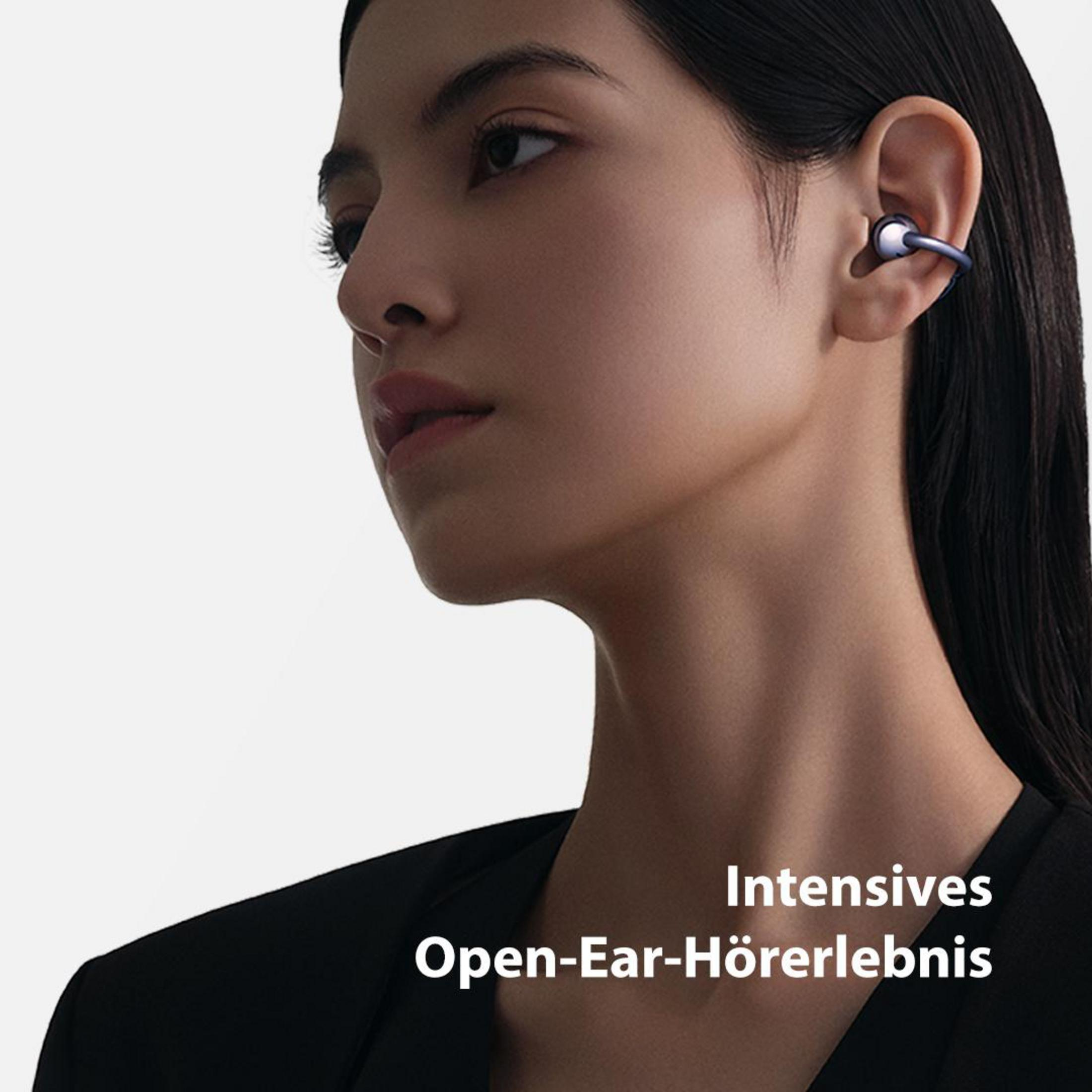 Kobieta w czarnej koszuli i niebieskim słuchawce. Tekst: 'Intensives Open-Ear-Hörerlebnis'.