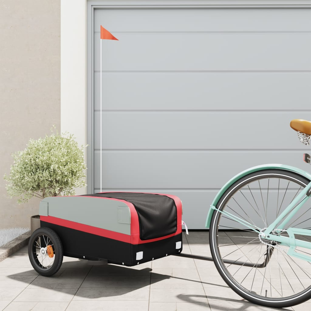 Ein Fahrrad, das einen rot-grauen Anhänger mit einer kleinen orangefarbenen Fahne zieht.