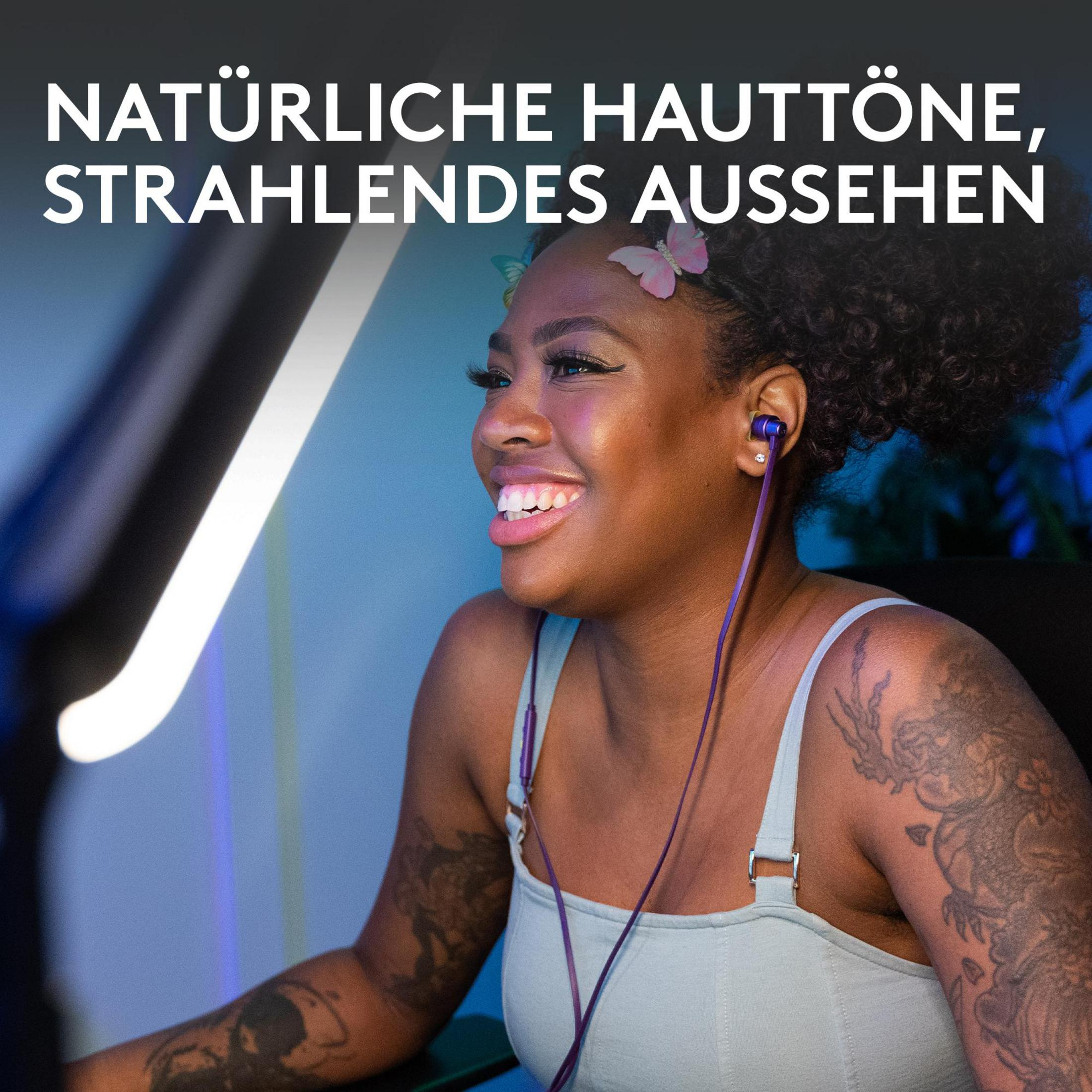 Mujer sonriente con auriculares y tatuajes, iluminada por luz brillante. Texto: Tonos de piel naturales, aspecto radiante.