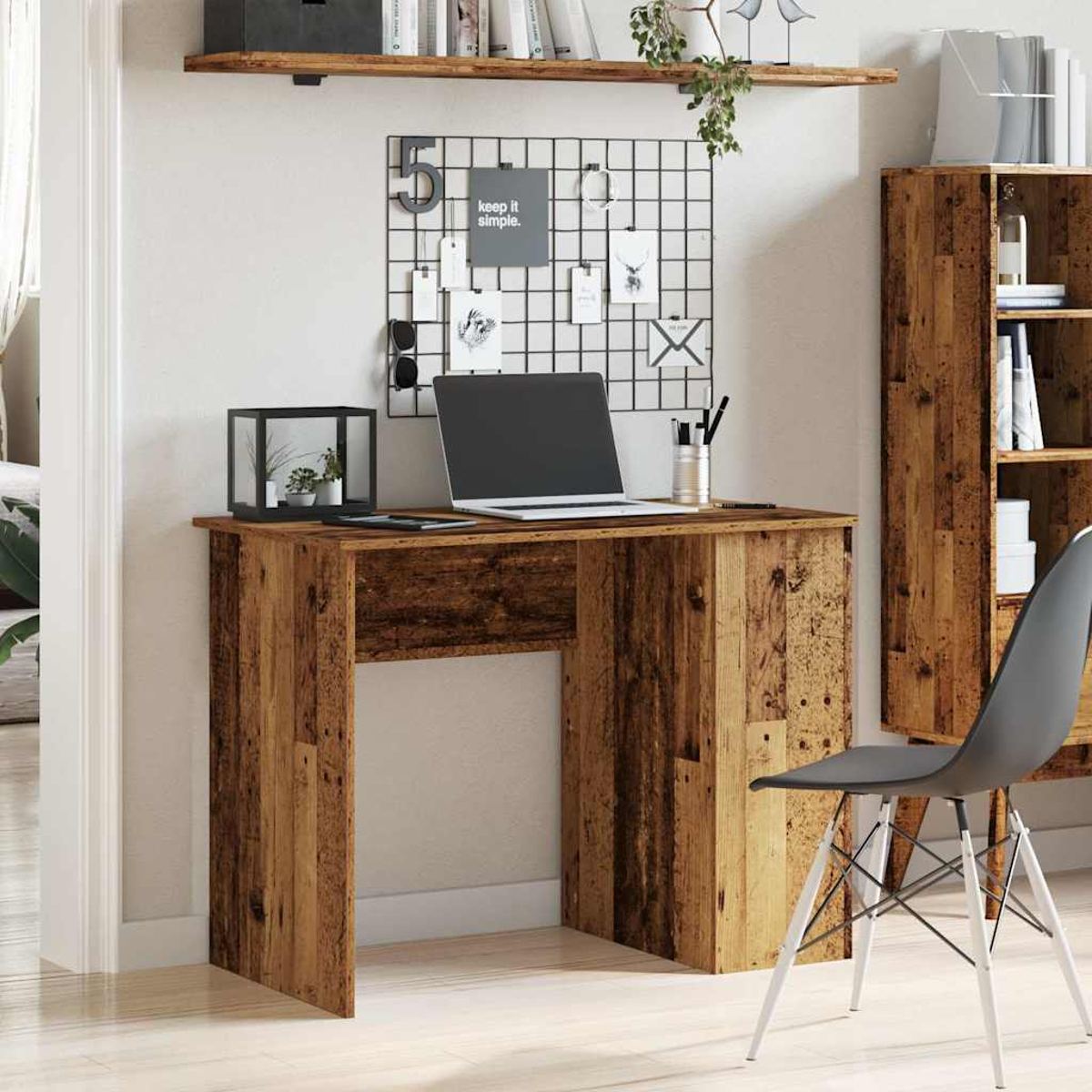 Ein Holzschreibtisch mit Laptop, Dekorationen und Regal. Ein grauer Stuhl ist in der rechten Ecke.