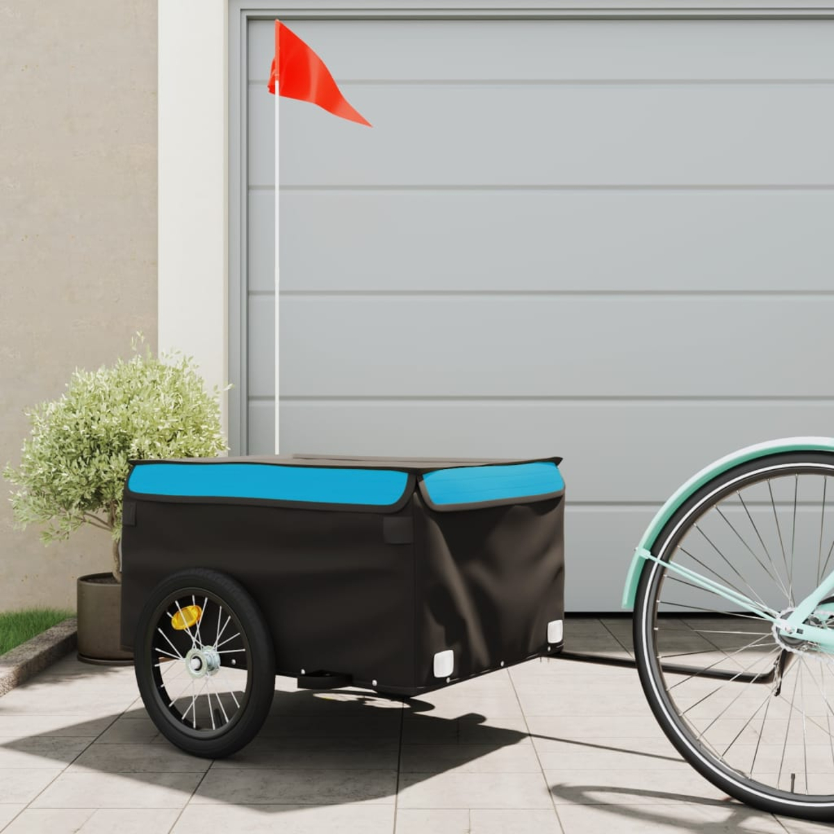 Ein schwarz-blauer Fahrradanhänger mit roter Flagge und einem hellblauen Fahrradrad.