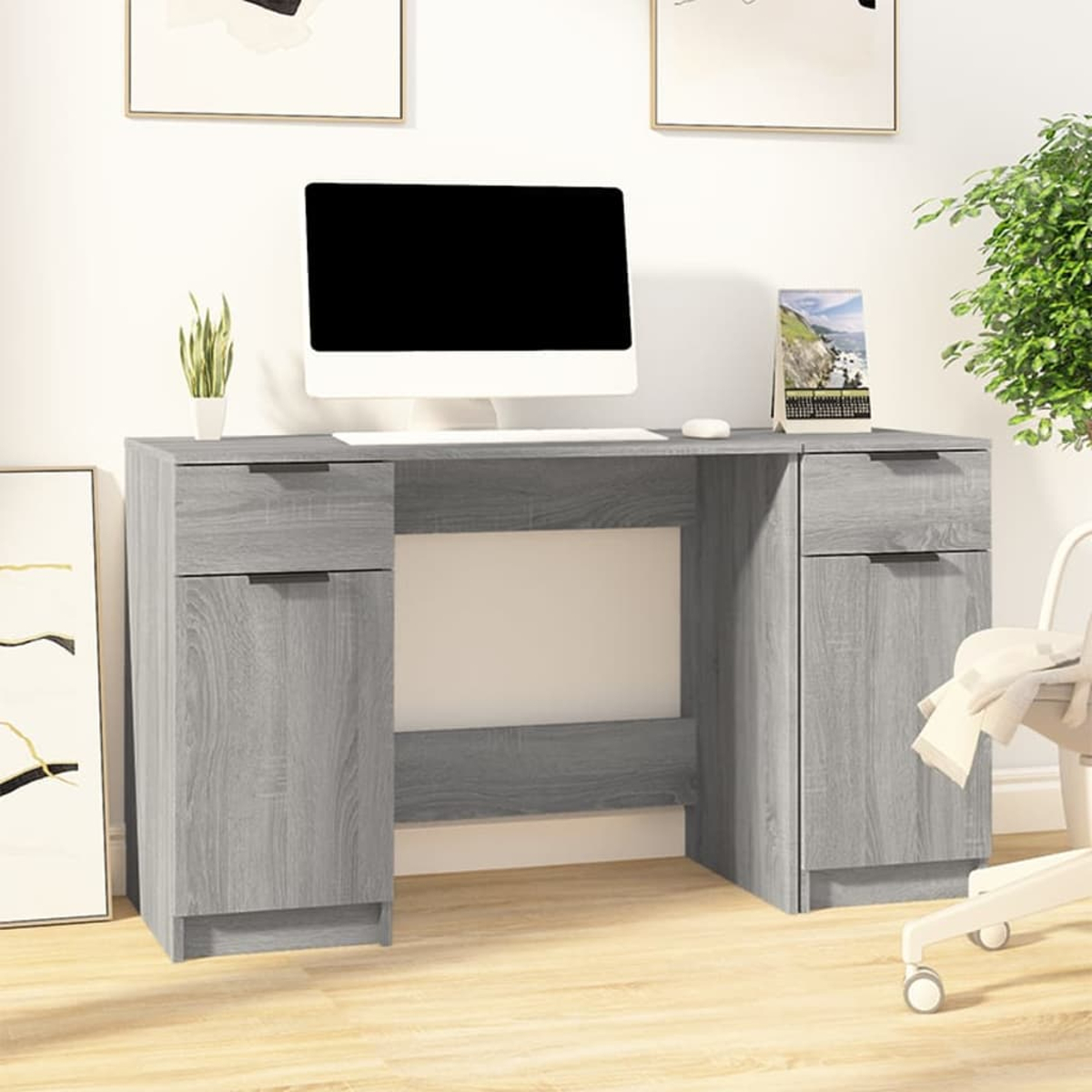 Ein grauer Schreibtisch mit Schubladen und einem Monitor, mit einer Pflanze und einem Stuhl.
