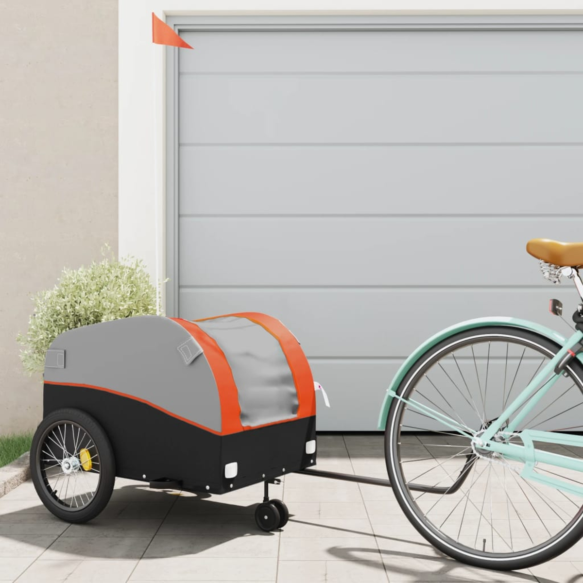 Ein Fahrrad mit Anhänger, gefüllt mit Pflanzen, geparkt vor einer Garage.
