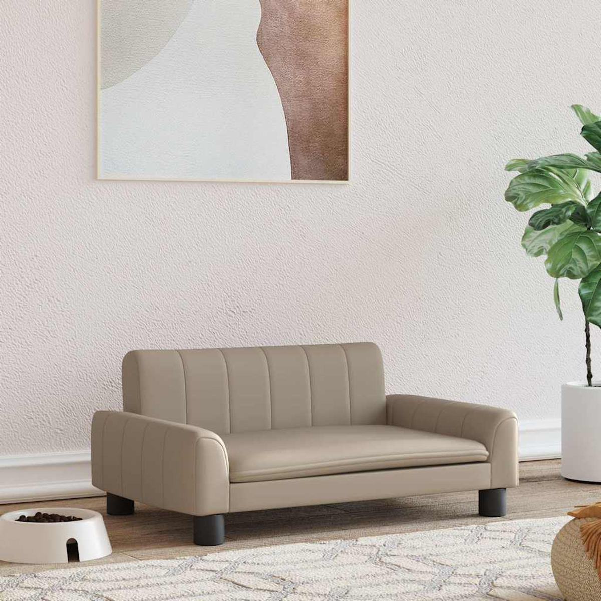 Beiges Haustiersofa mit schwarzen Beinen, Gemälde und Pflanze im Hintergrund.
