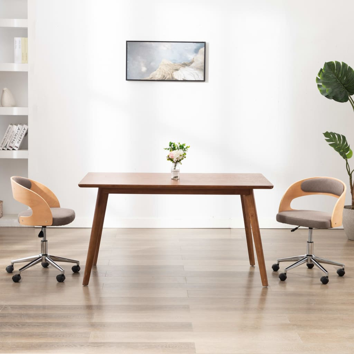 Ein Esszimmer mit einem Holztisch und zwei Stühlen. Es gibt ein Gemälde und eine Pflanze.