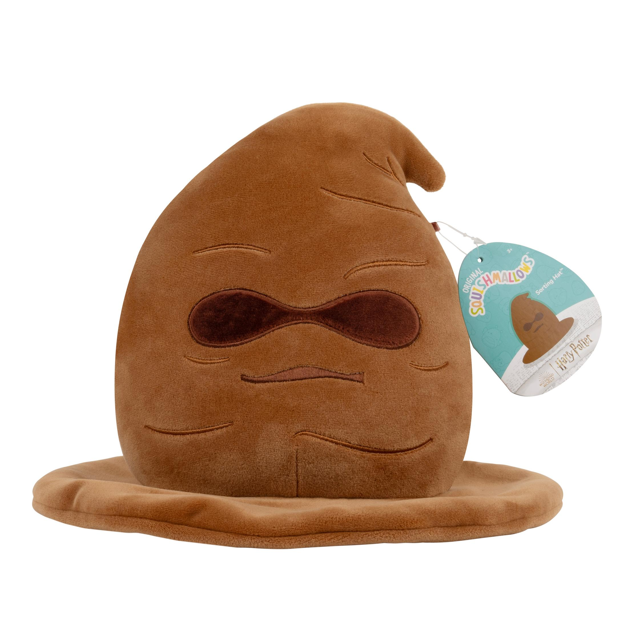 Un chapeau de tri en peluche marron de Harry Potter avec une étiquette. Le chapeau a un visage.
