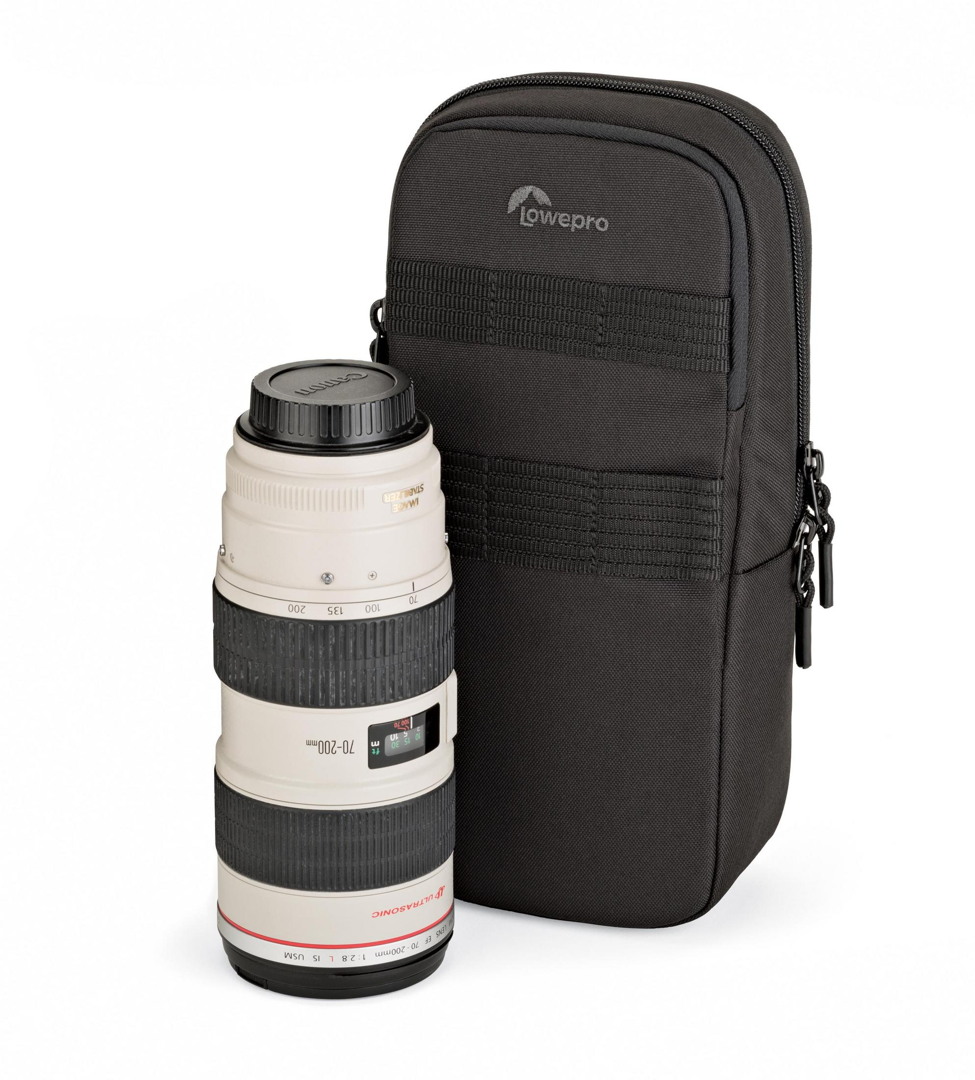 Ein Kameraobjektiv und eine schwarze Lowepro-Tasche auf Weiß. Das Objektiv ist weiß und schwarz.