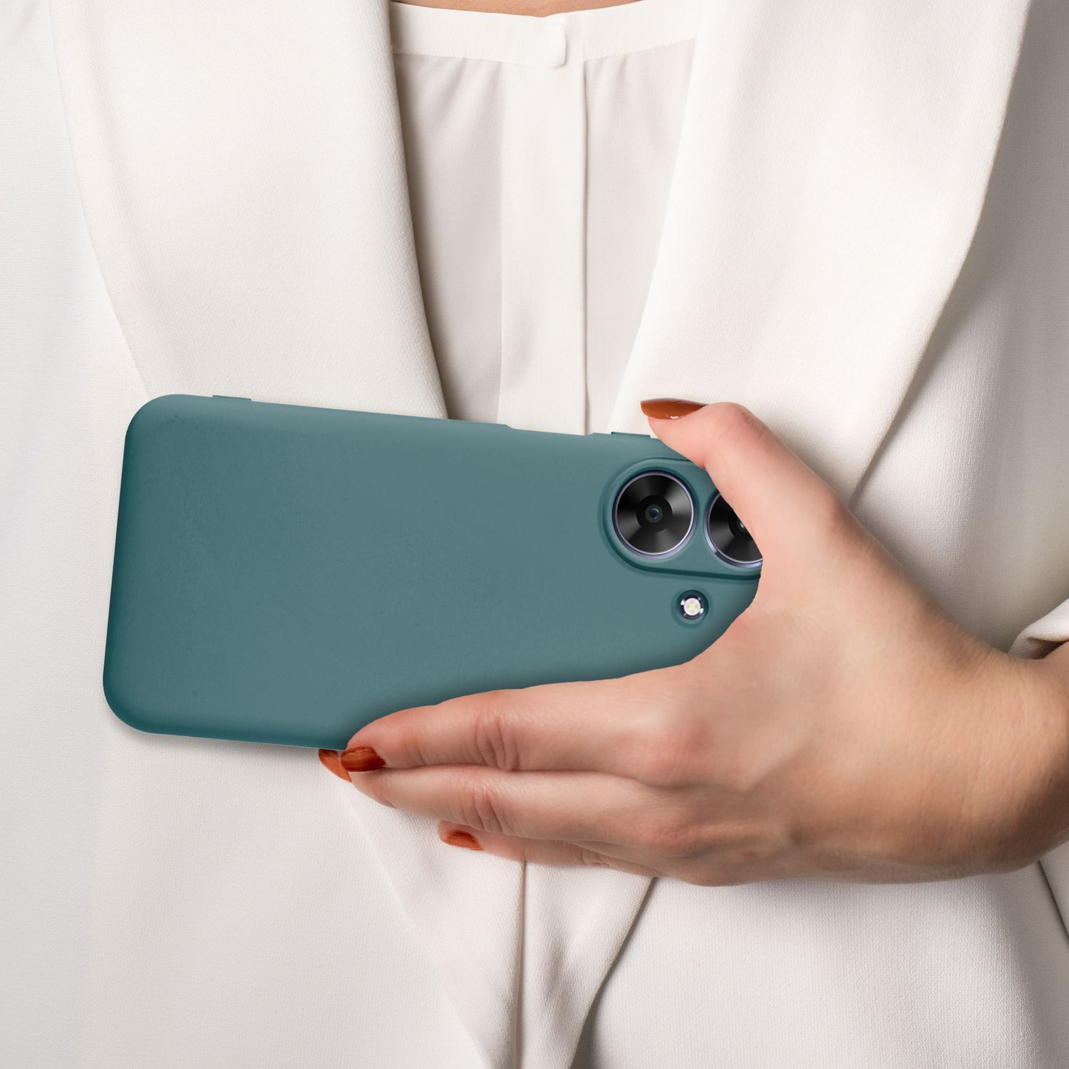 Ein türkisfarbenes Telefon in einer Hand. Die Person trägt einen weißen Blazer. Die Nägel sind braun lackiert.